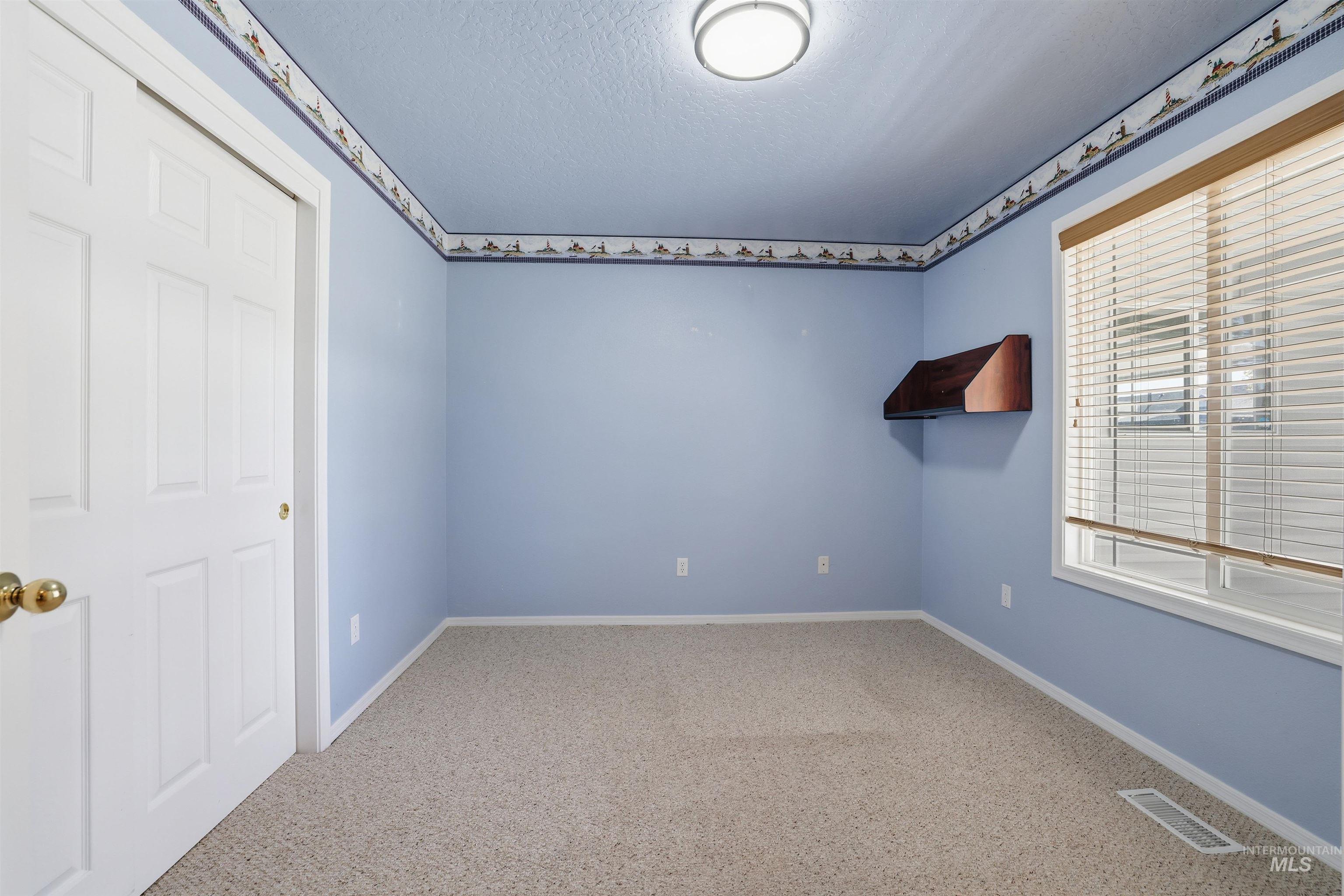 Empty room featuring carpet flooring and a textured ceiling