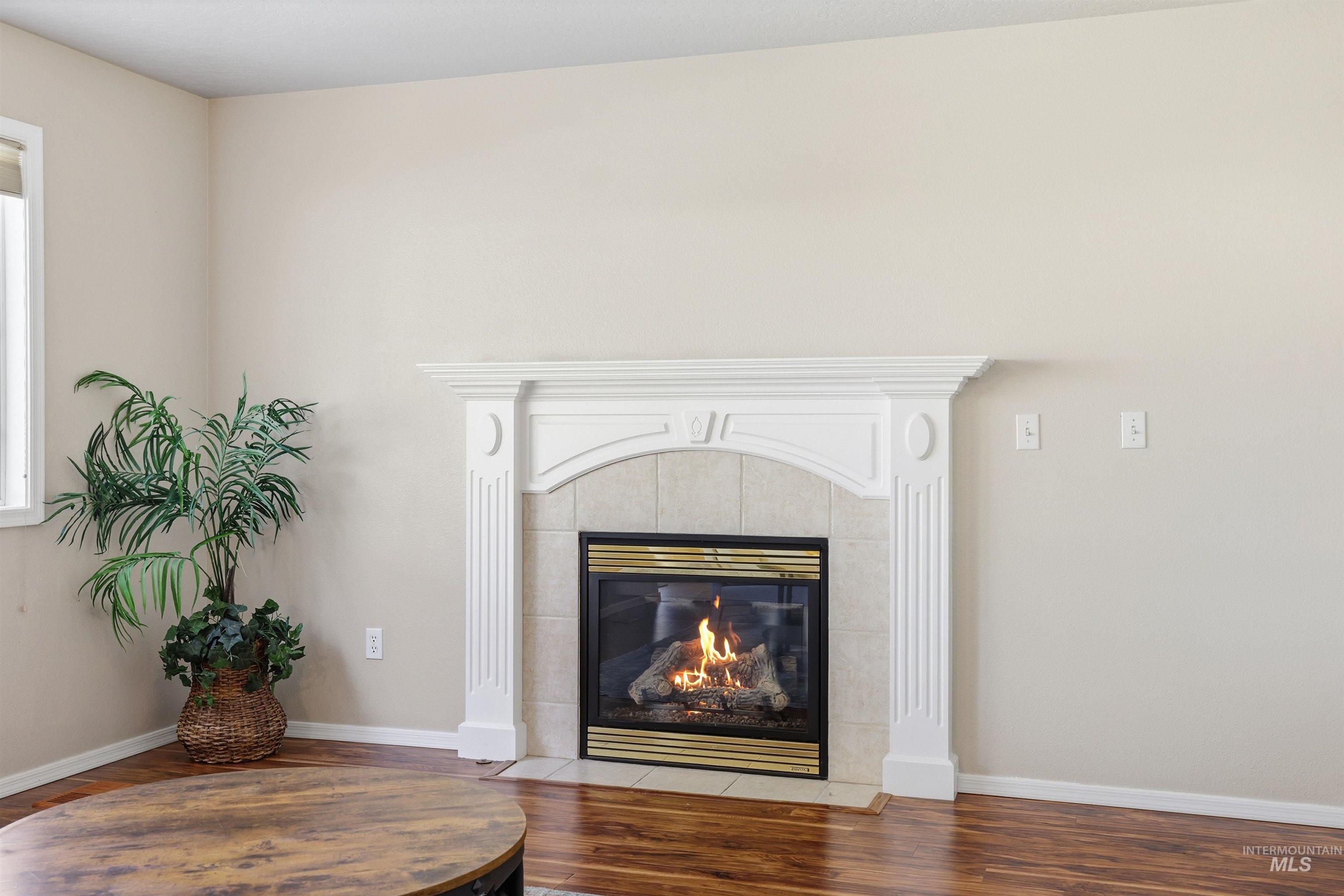 Detailed view of wood finished floors and a fireplace