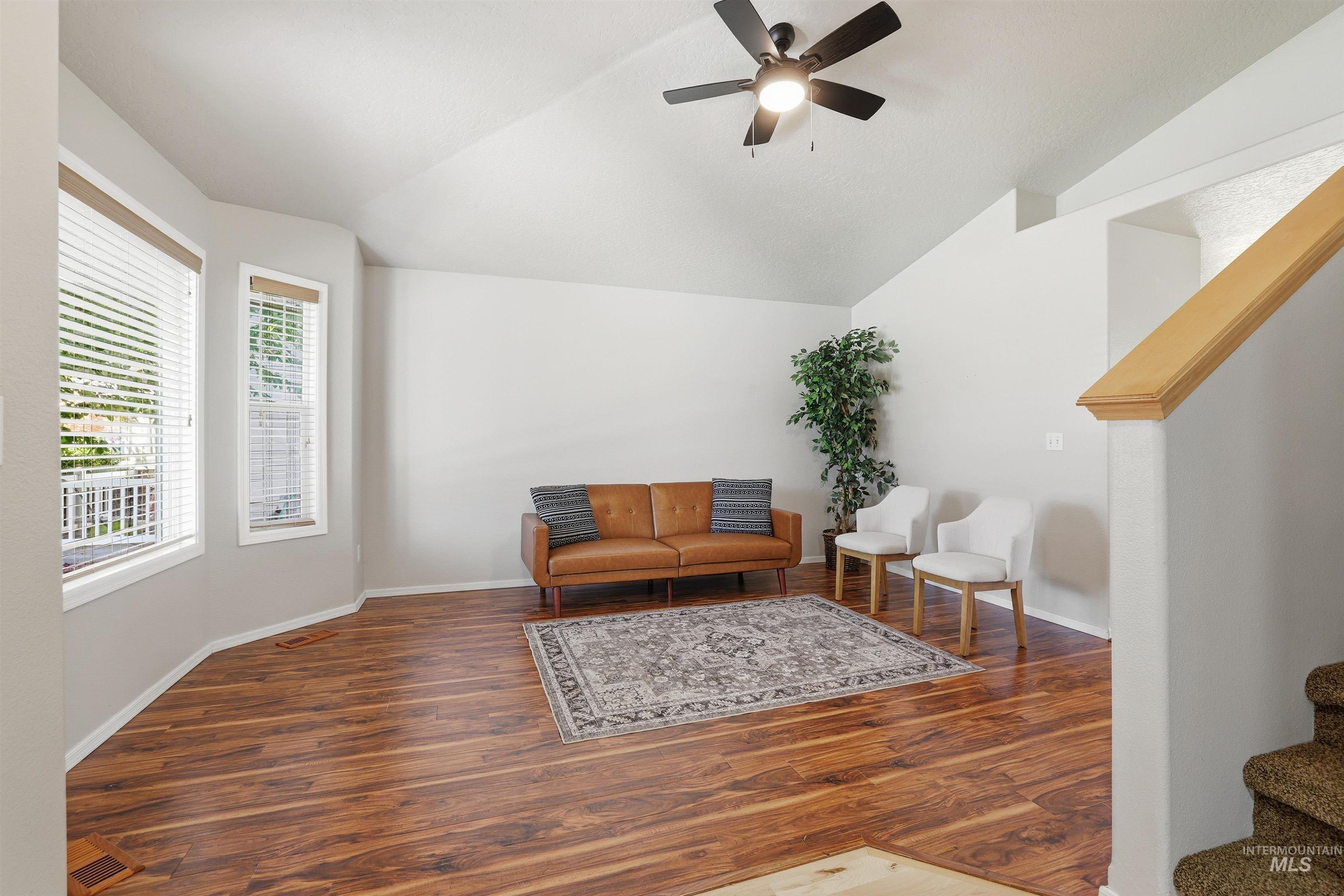Sitting room featuring stairway, wood finished floors, lofted ceiling, and a ceiling fan