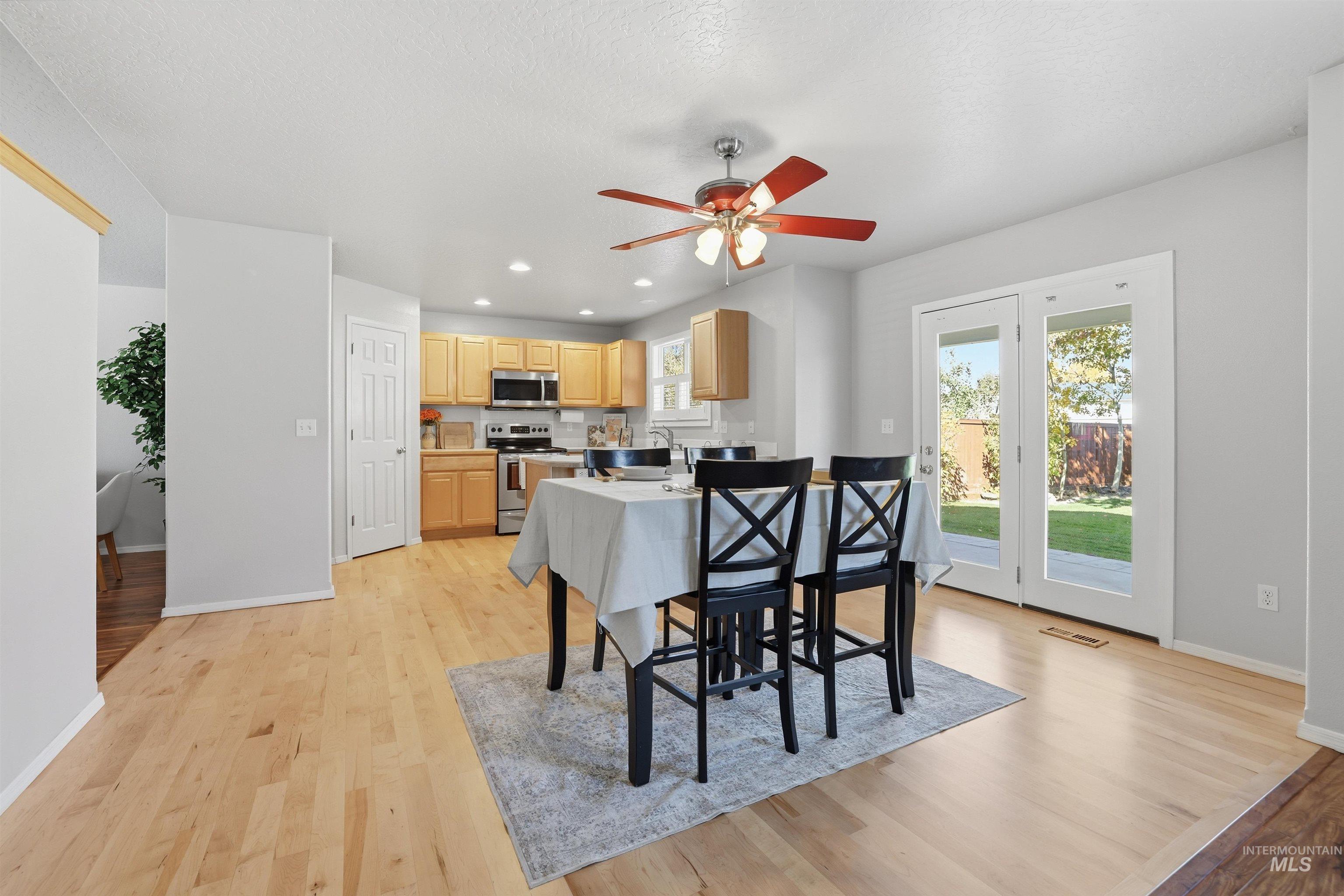 Dining area with light wood finished floors, ceiling fan, and recessed lighting