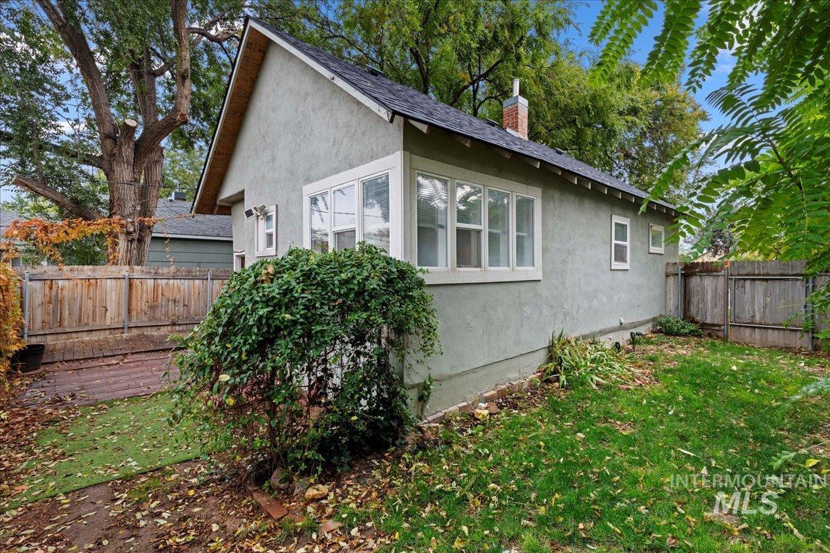 View of home's exterior with a fenced backyard, stucco siding, and roof with shingles