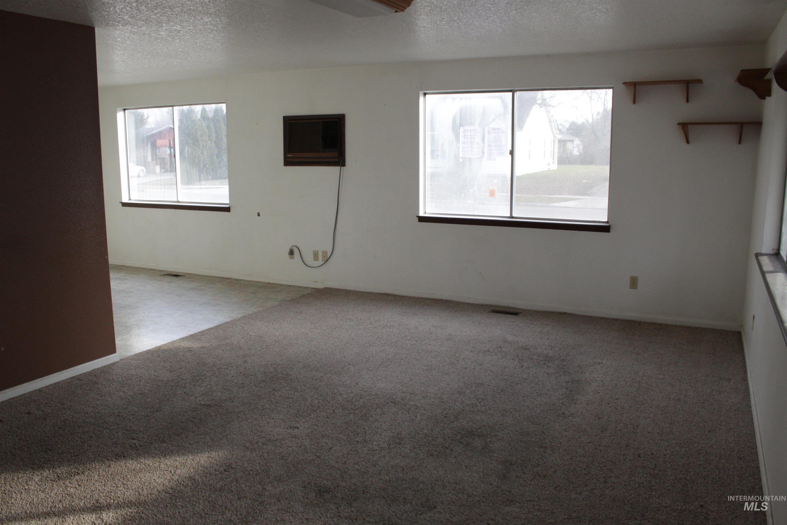 Empty room with a textured ceiling and carpet flooring