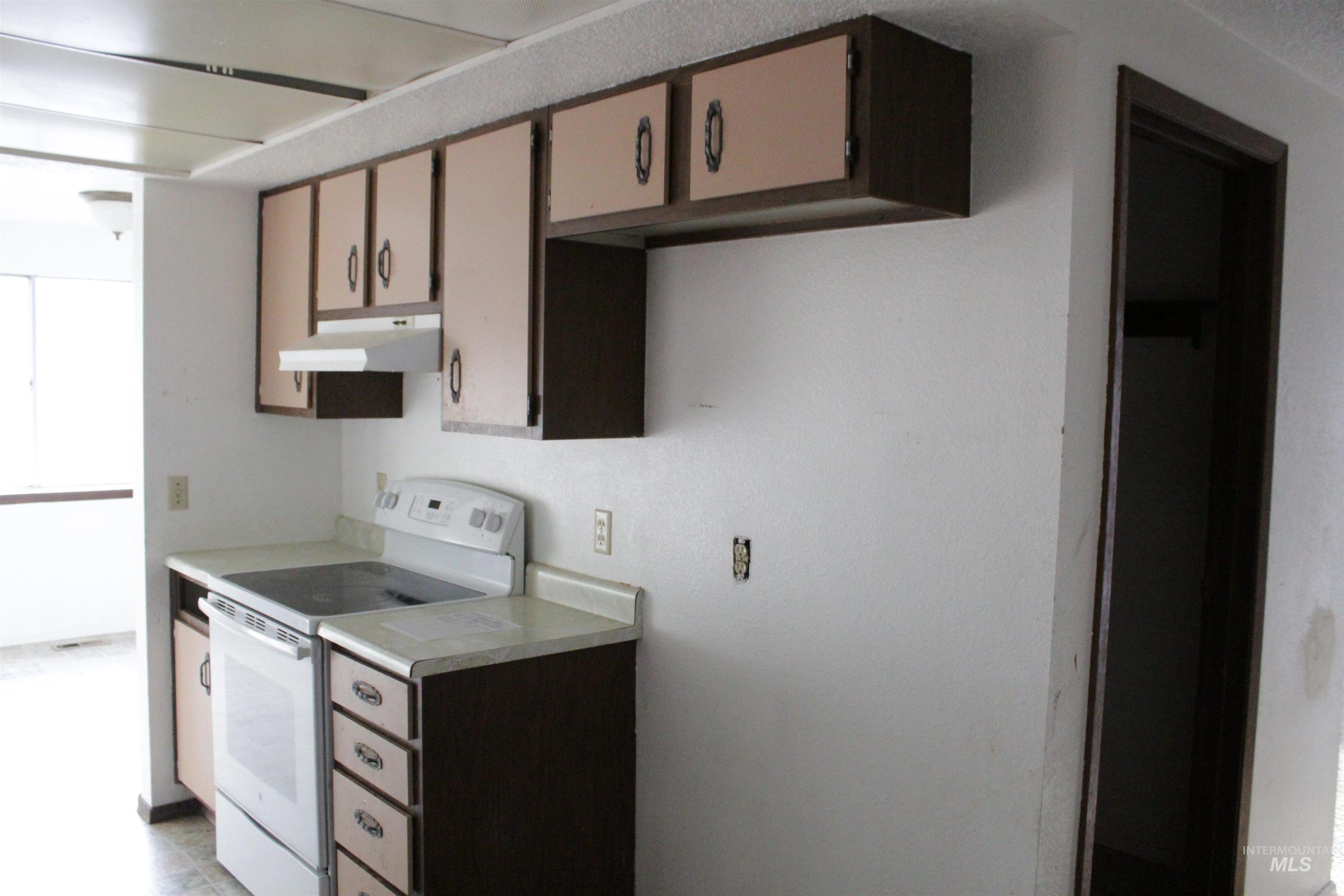 Kitchen featuring electric stove and light countertops