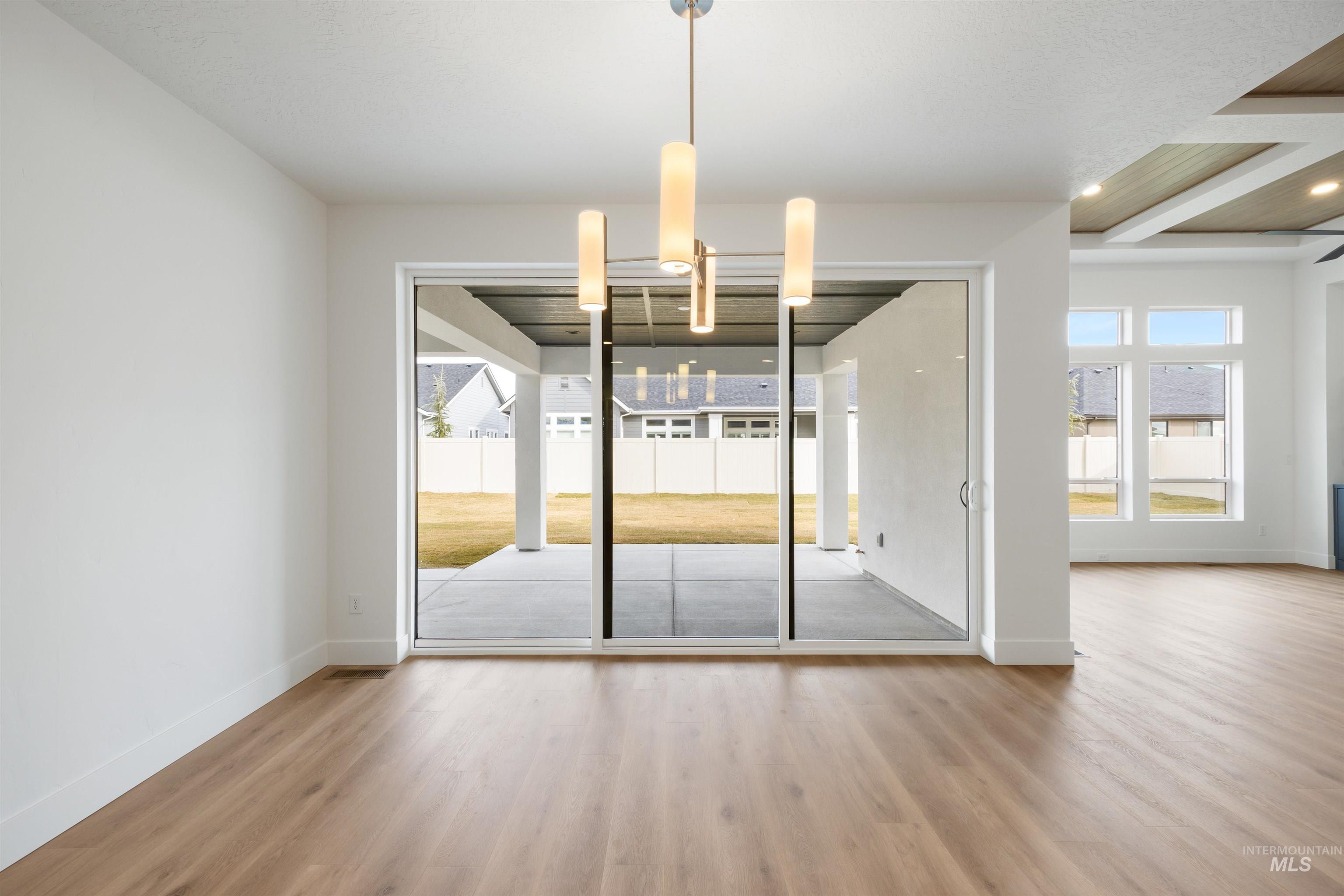 Unfurnished dining area featuring light wood finished floors and suspended lighting