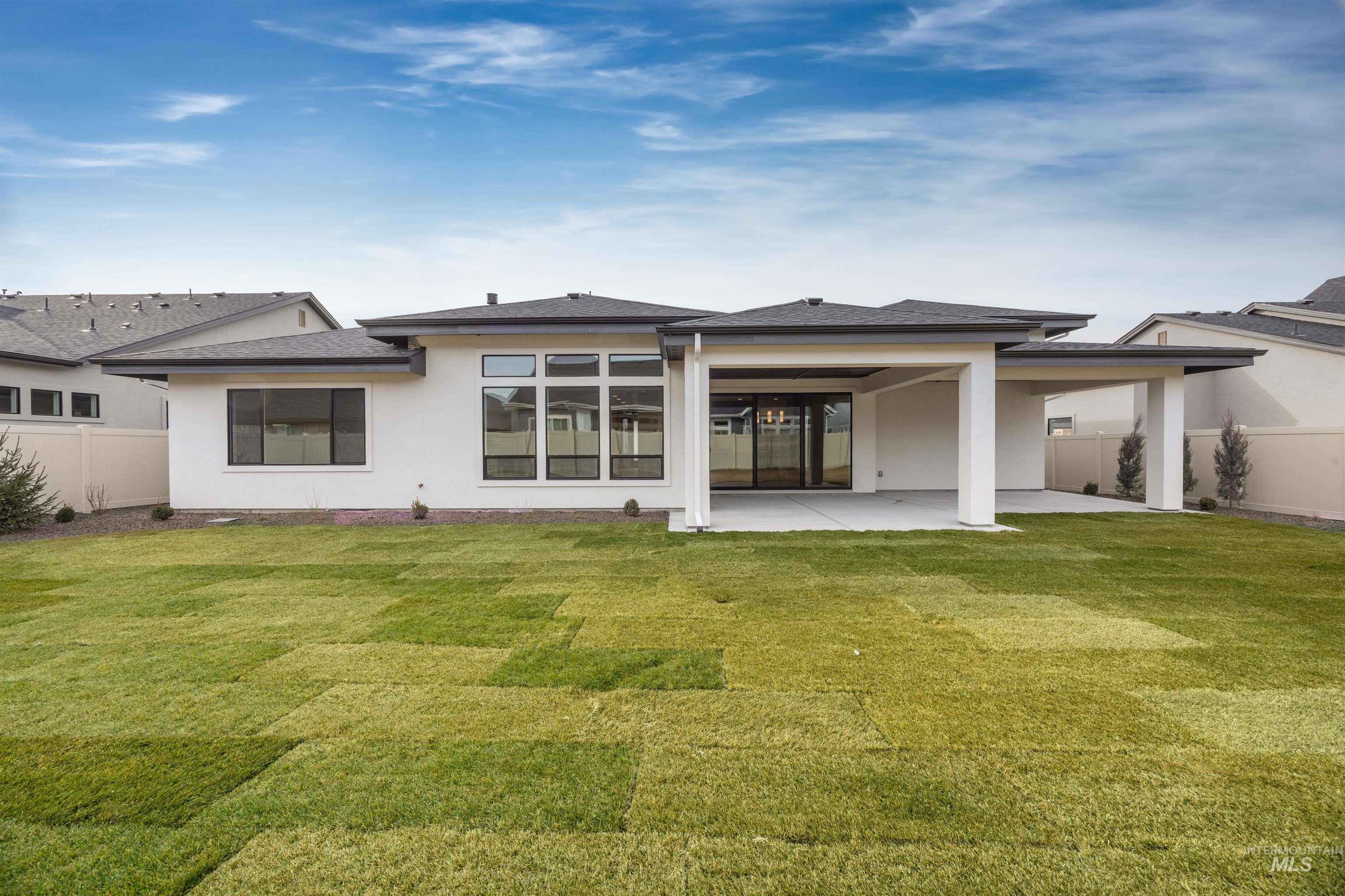 Back of property with a patio, stucco siding, and a shingled roof