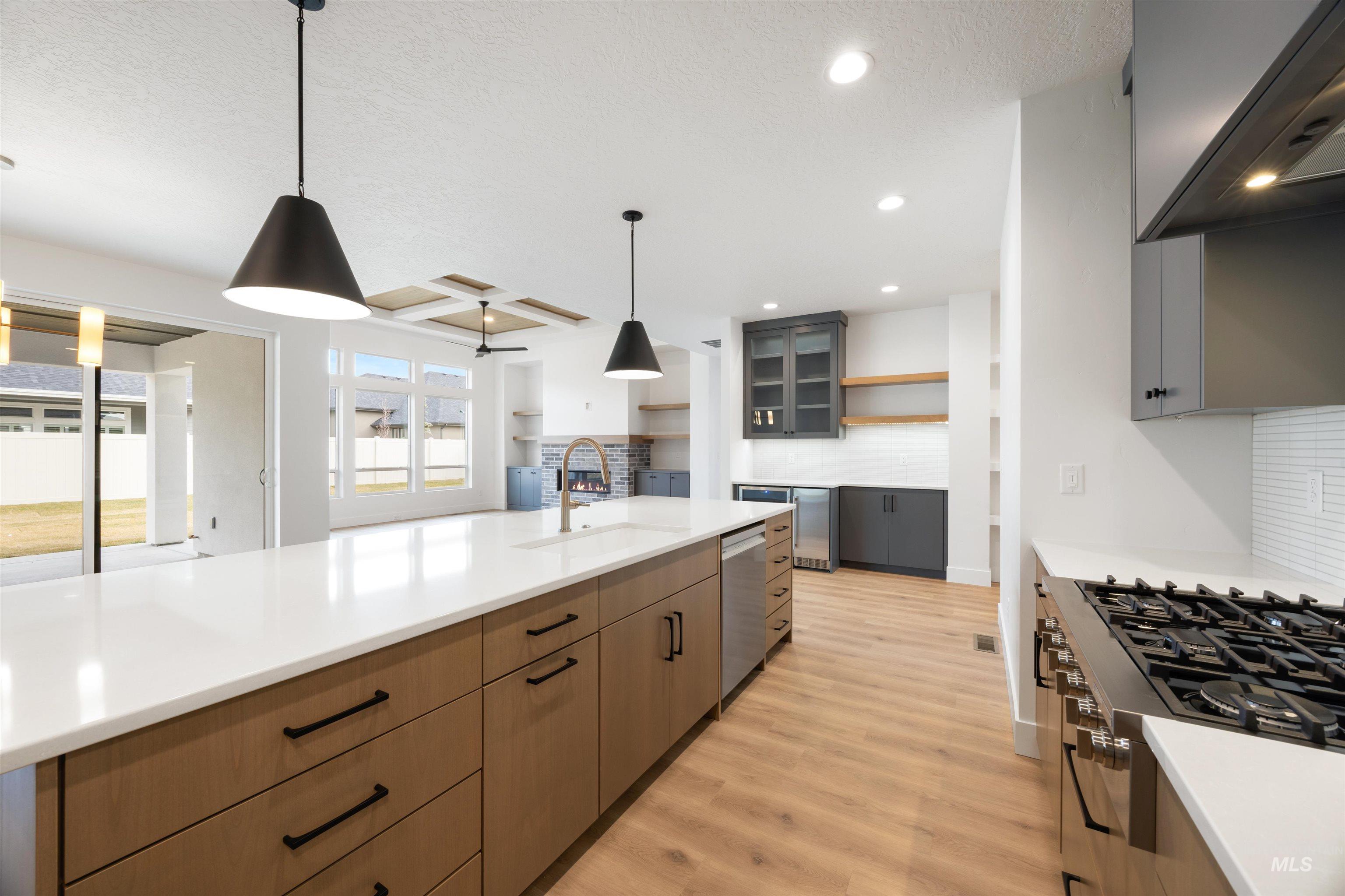 Dual tone kitchen with dual tone cabinets, range hood, open shelves, stainless steel appliances, and light wood-style floors