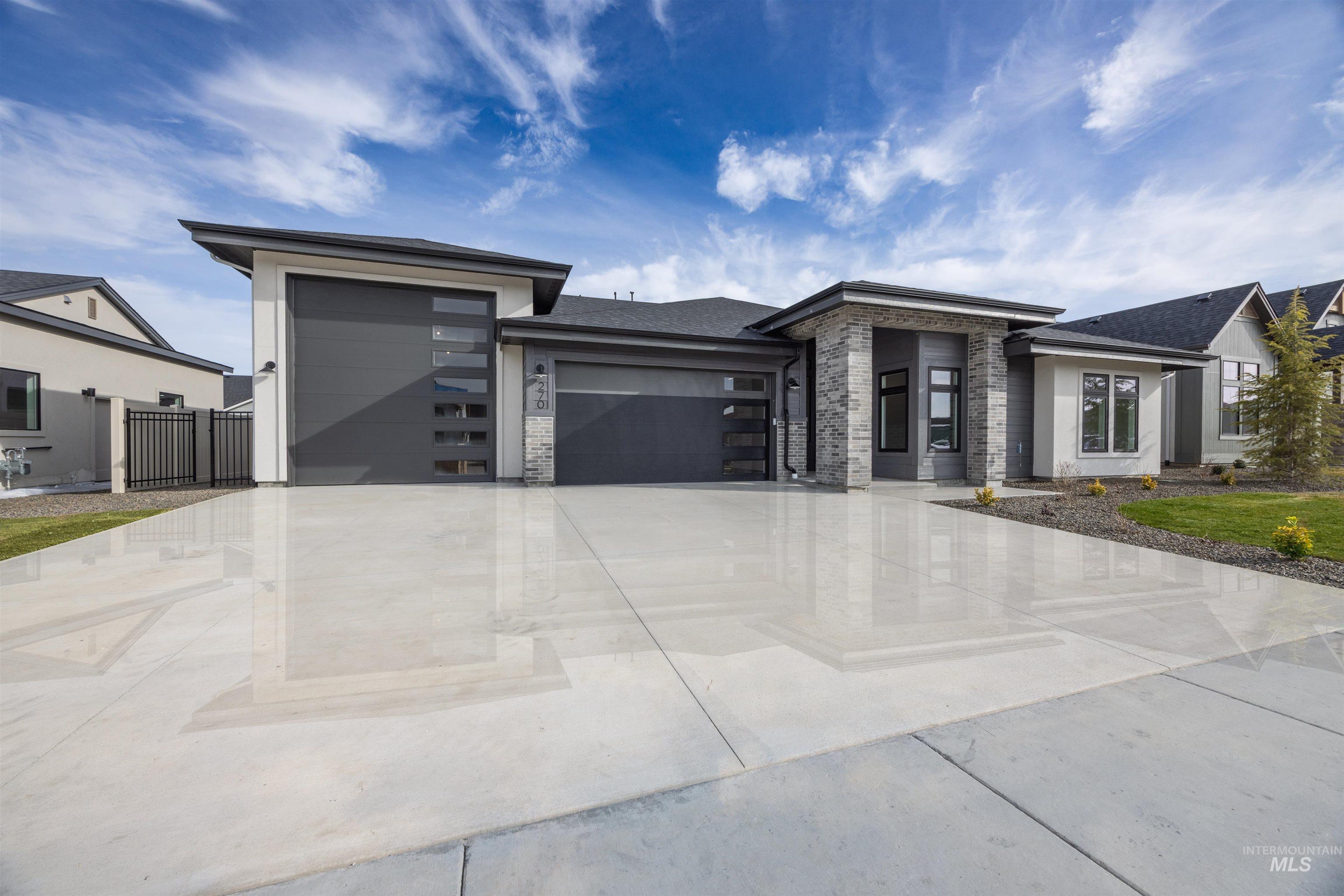 Prairie-style home with a garage, concrete driveway, and stone siding