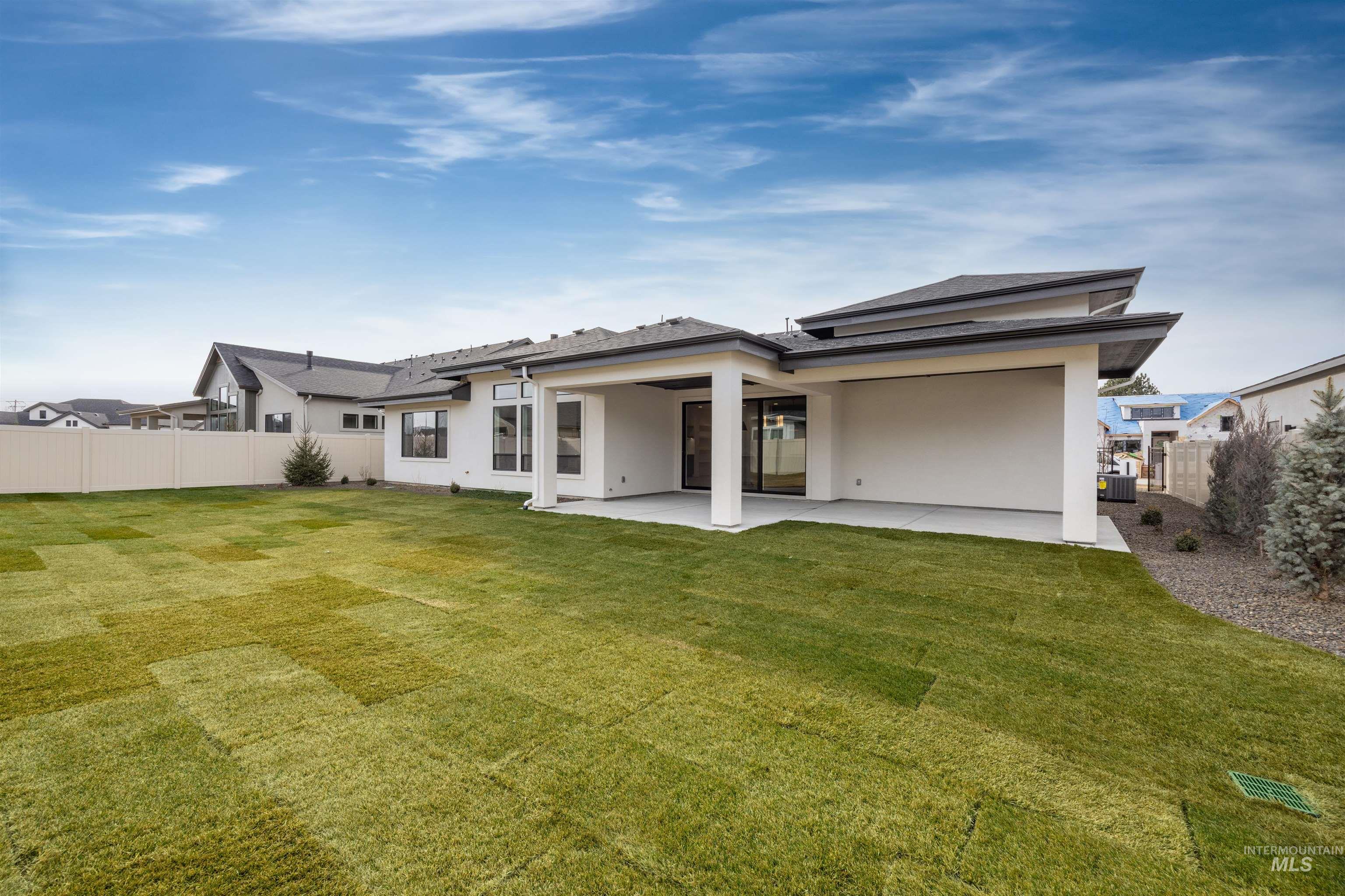 Rear view of property with a fenced backyard, stucco siding, and a patio