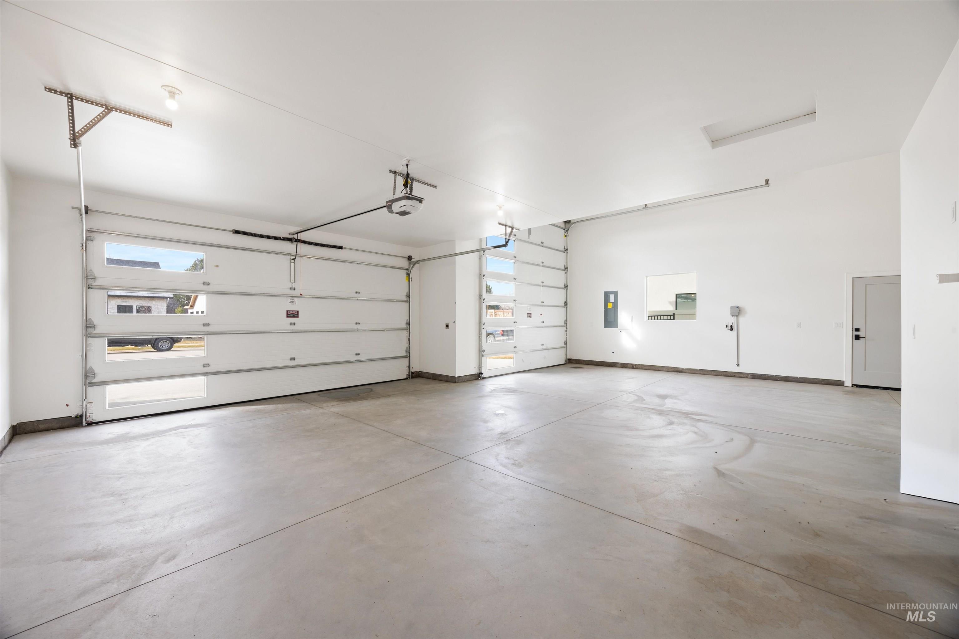 Garage with electric panel and baseboards