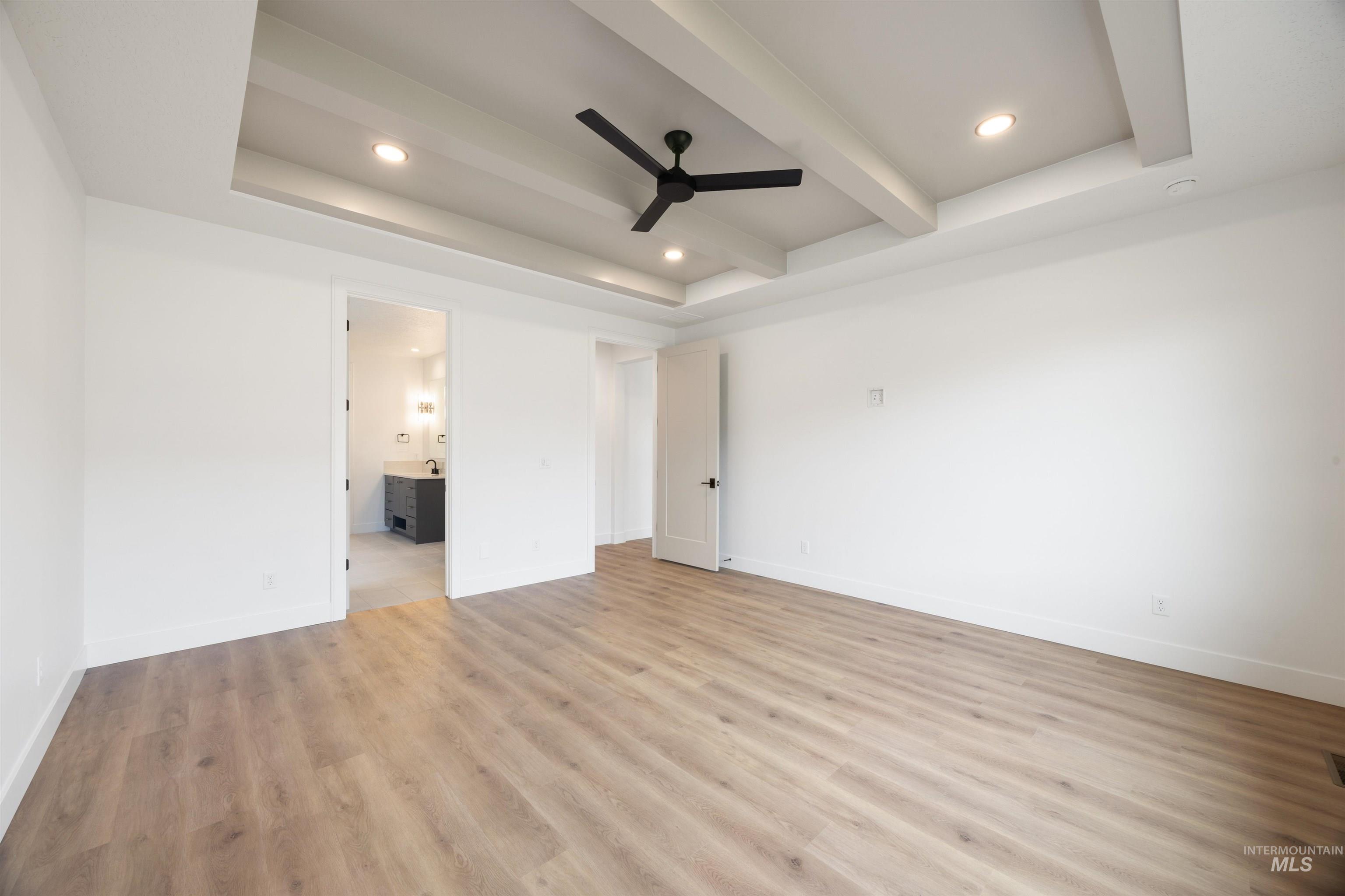 Unfurnished bedroom featuring recessed lighting, light wood finished floors, a ceiling fan, beam ceiling, and ensuite bath