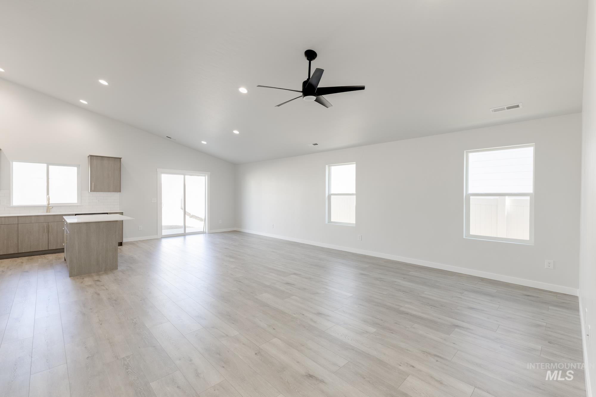 Unfurnished living room featuring recessed lighting, light wood finished floors, vaulted ceiling, and ceiling fan