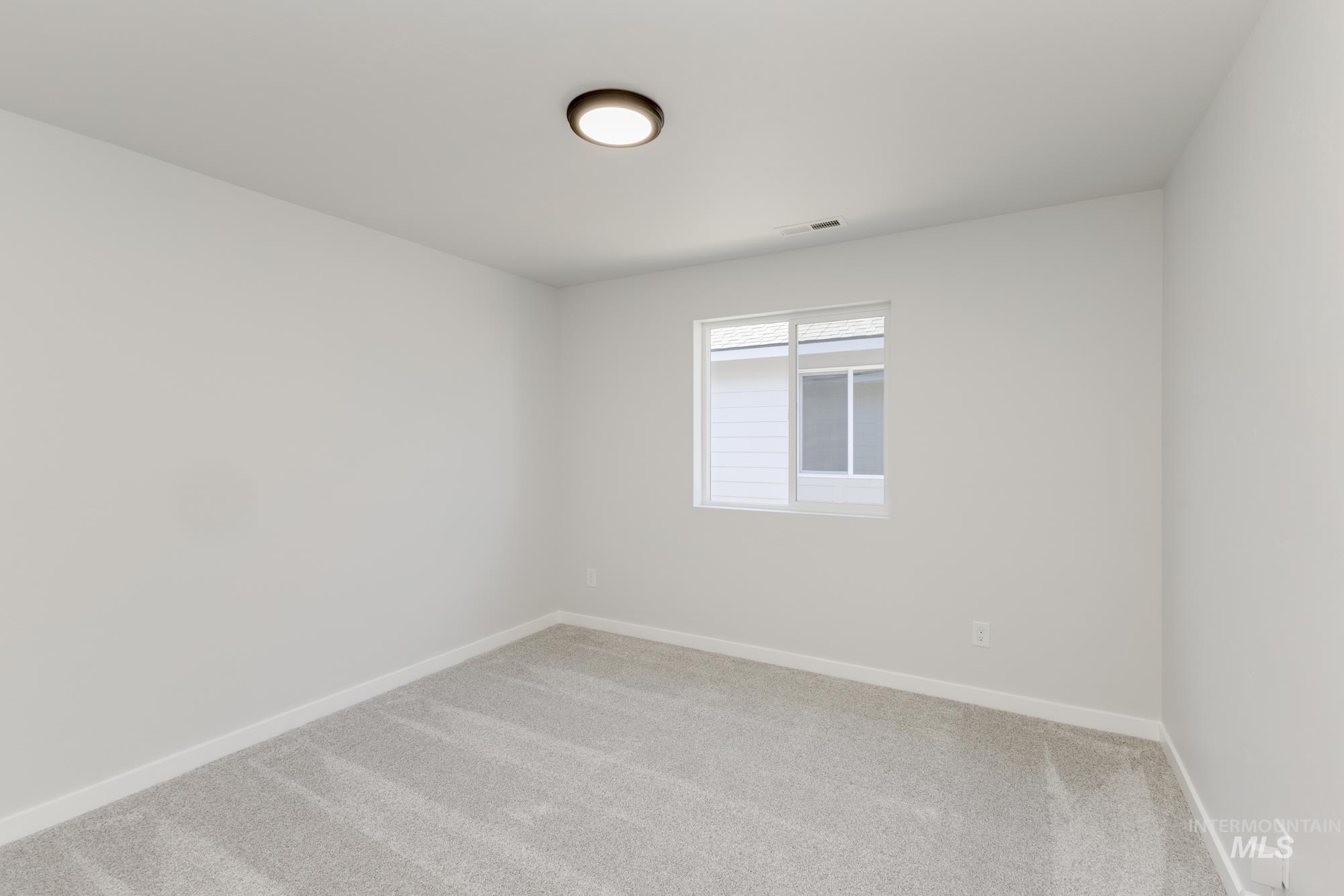 Carpeted empty room featuring baseboards