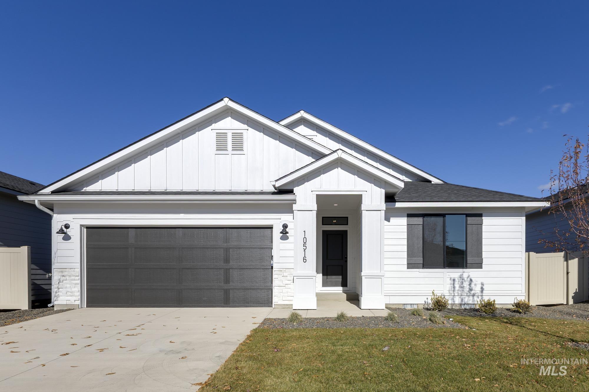 Modern farmhouse featuring board and batten siding, driveway, and a garage