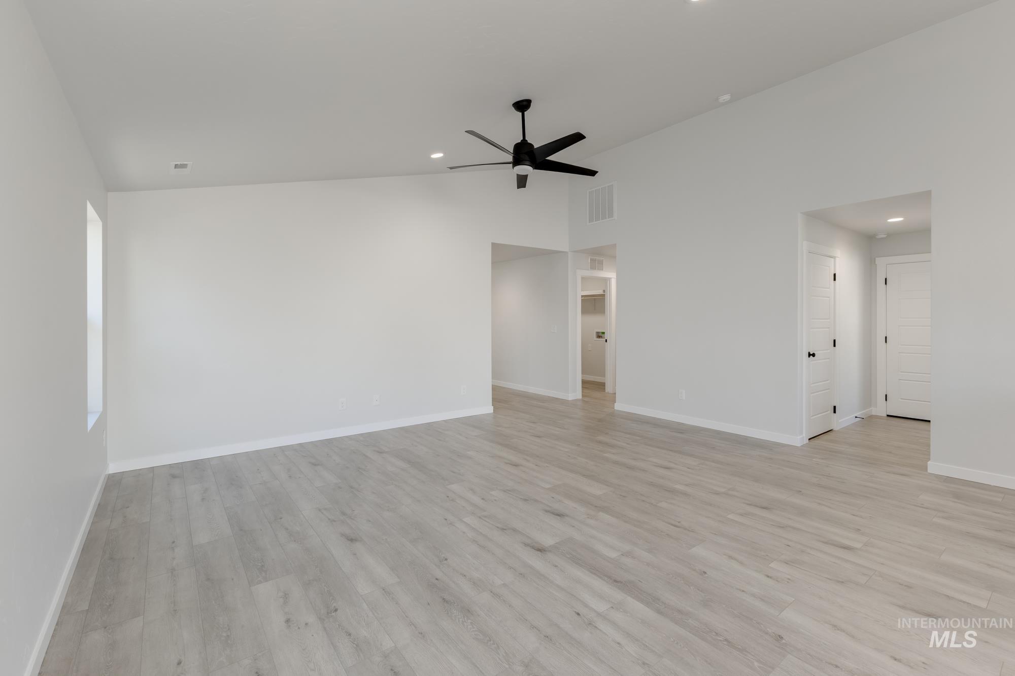 Unfurnished living room featuring vaulted ceiling, light wood-style floors, recessed lighting, and ceiling fan