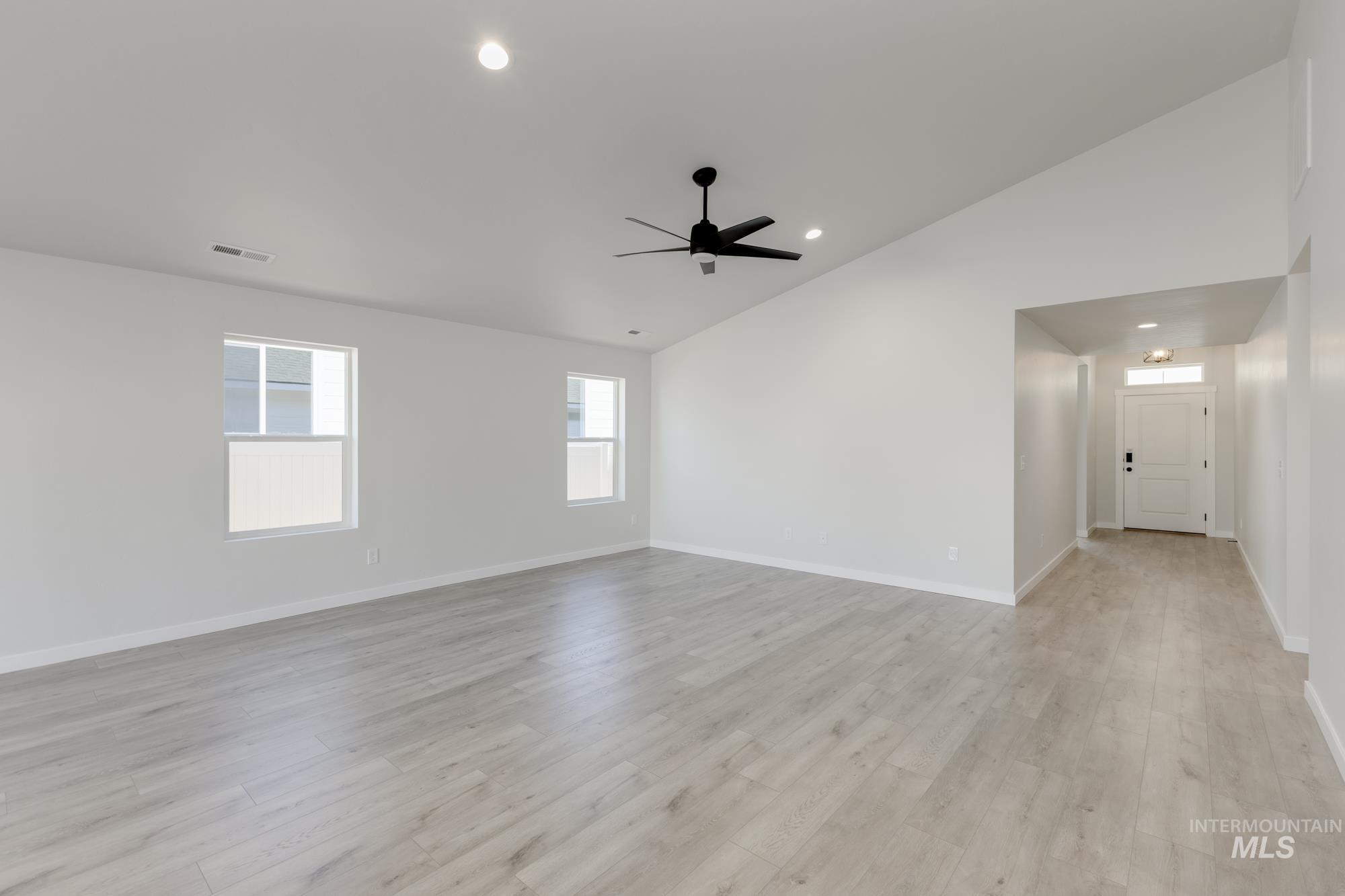 Spare room featuring vaulted ceiling, light wood finished floors, recessed lighting, and ceiling fan