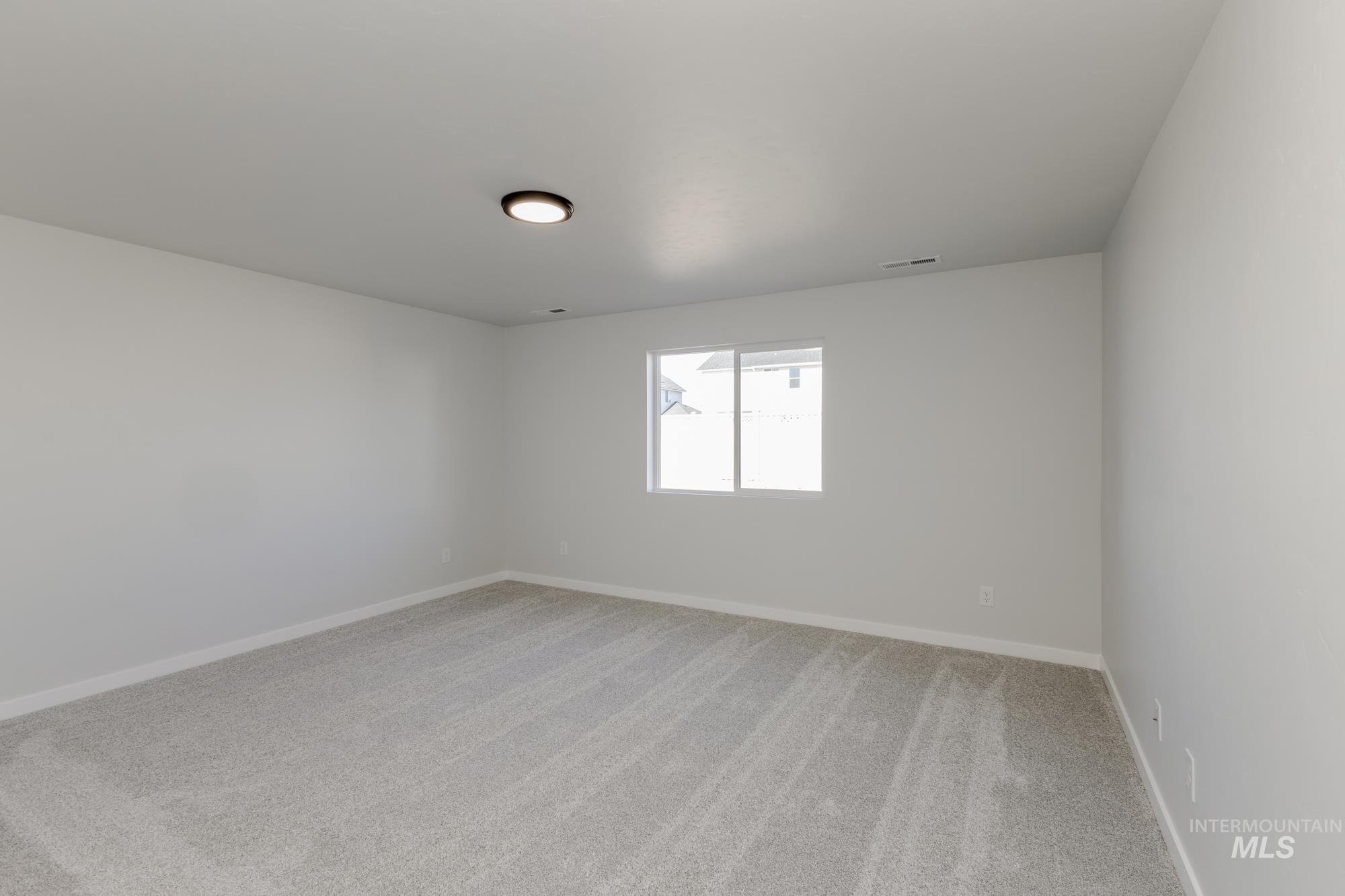 Spare room with light colored carpet and baseboards