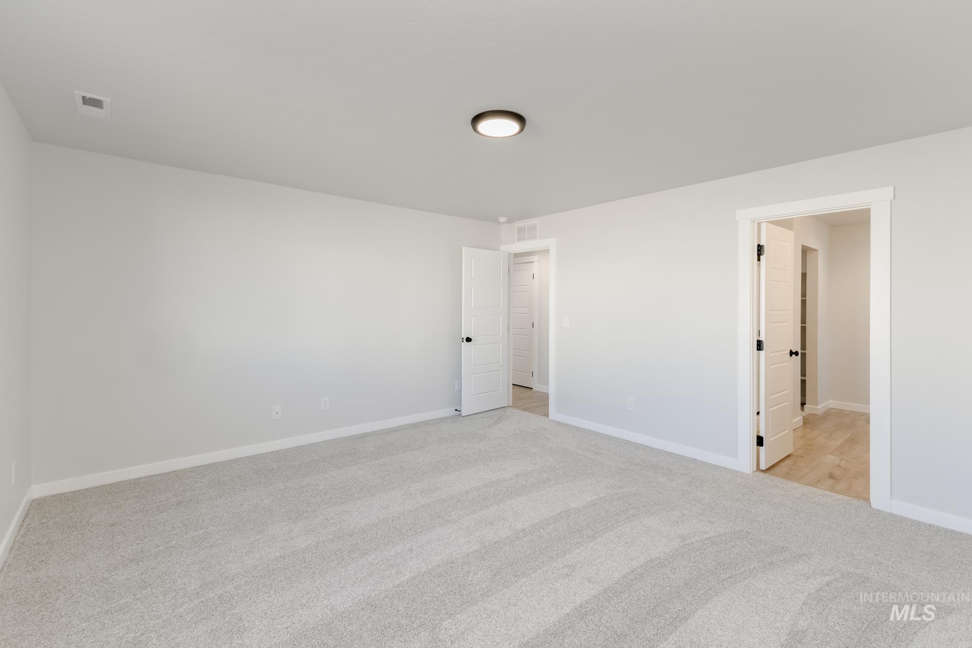 Unfurnished bedroom featuring light colored carpet and baseboards