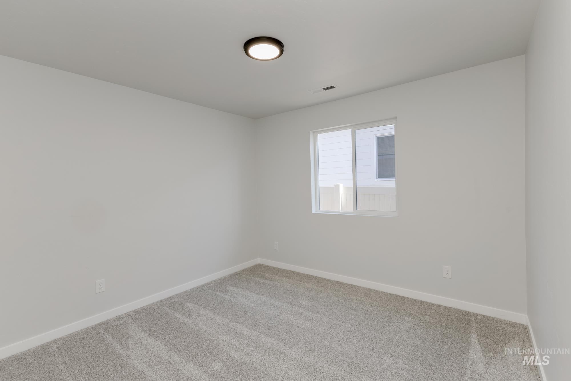 Carpeted spare room with baseboards