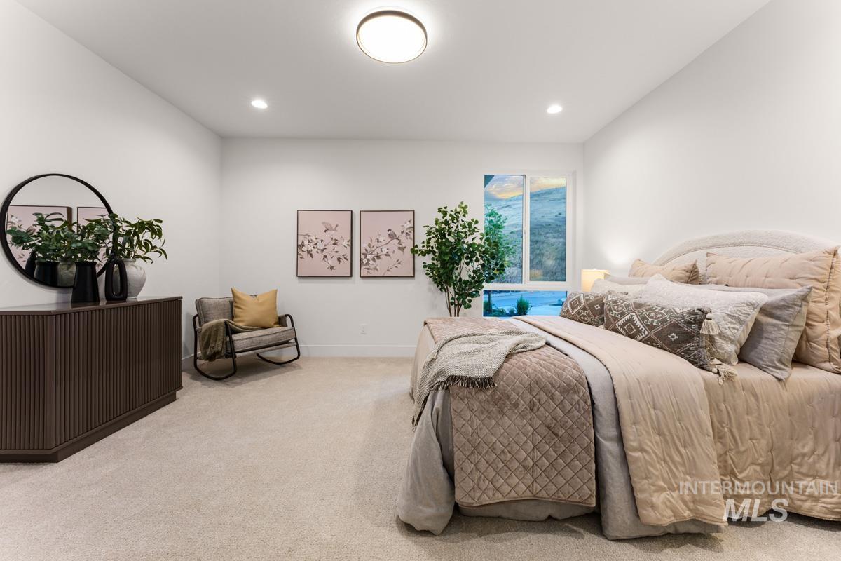 Spacious room featuring neutral carpeting, recessed lighting, and a large window offering exterior scenery