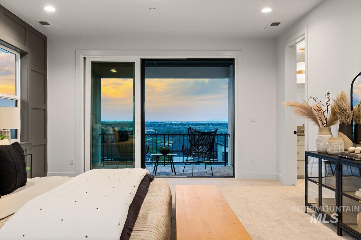 Bedroom featuring carpeted flooring and a wall of windows, including sliding glass doors opening to a balcony