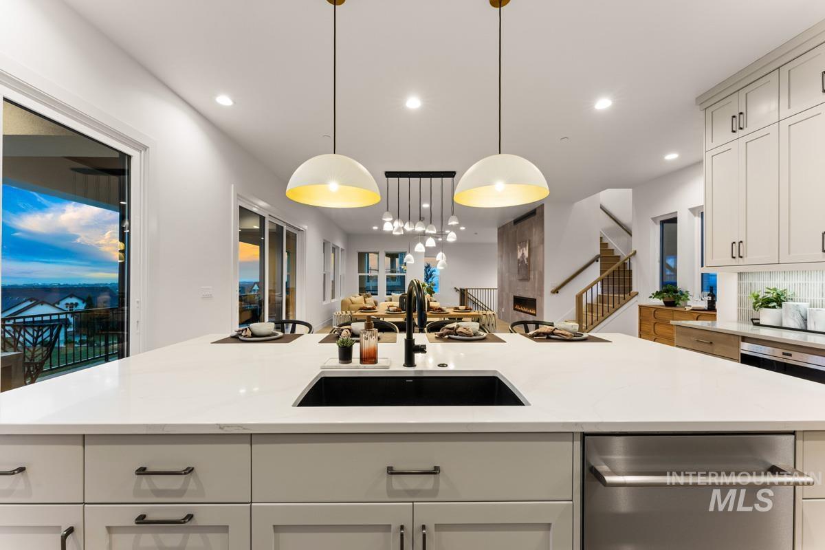Expansive kitchen island featuring a deep undermount sink, a sleek black faucet, and two decorative pendant lights