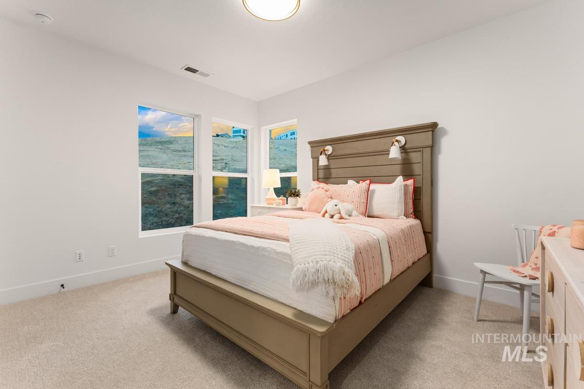 Bedroom featuring neutral-toned carpeting, white walls, and a contemporary ceiling light fixture
