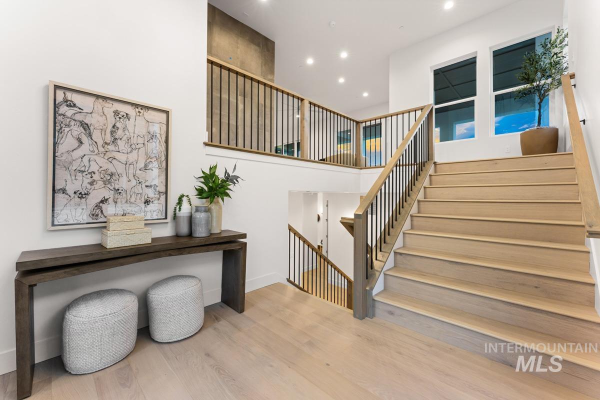 Staircase with light wood-finish treads and risers, complemented by a black metal baluster railing system
