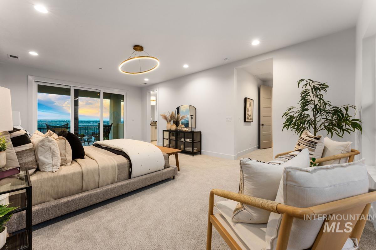 Spacious room featuring light gray carpeting, recessed lighting, and a modern circular chandelier