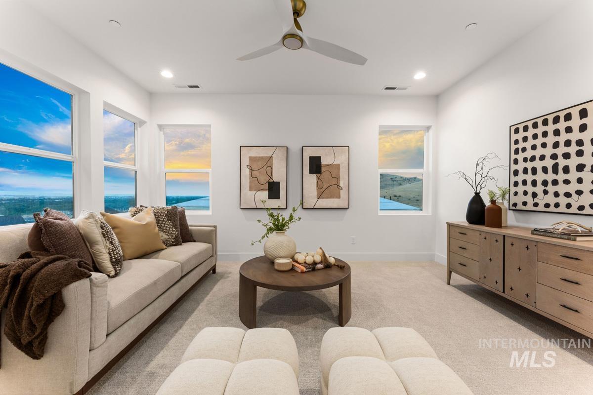 Bright living space featuring multiple windows, recessed lighting, and a contemporary ceiling fan