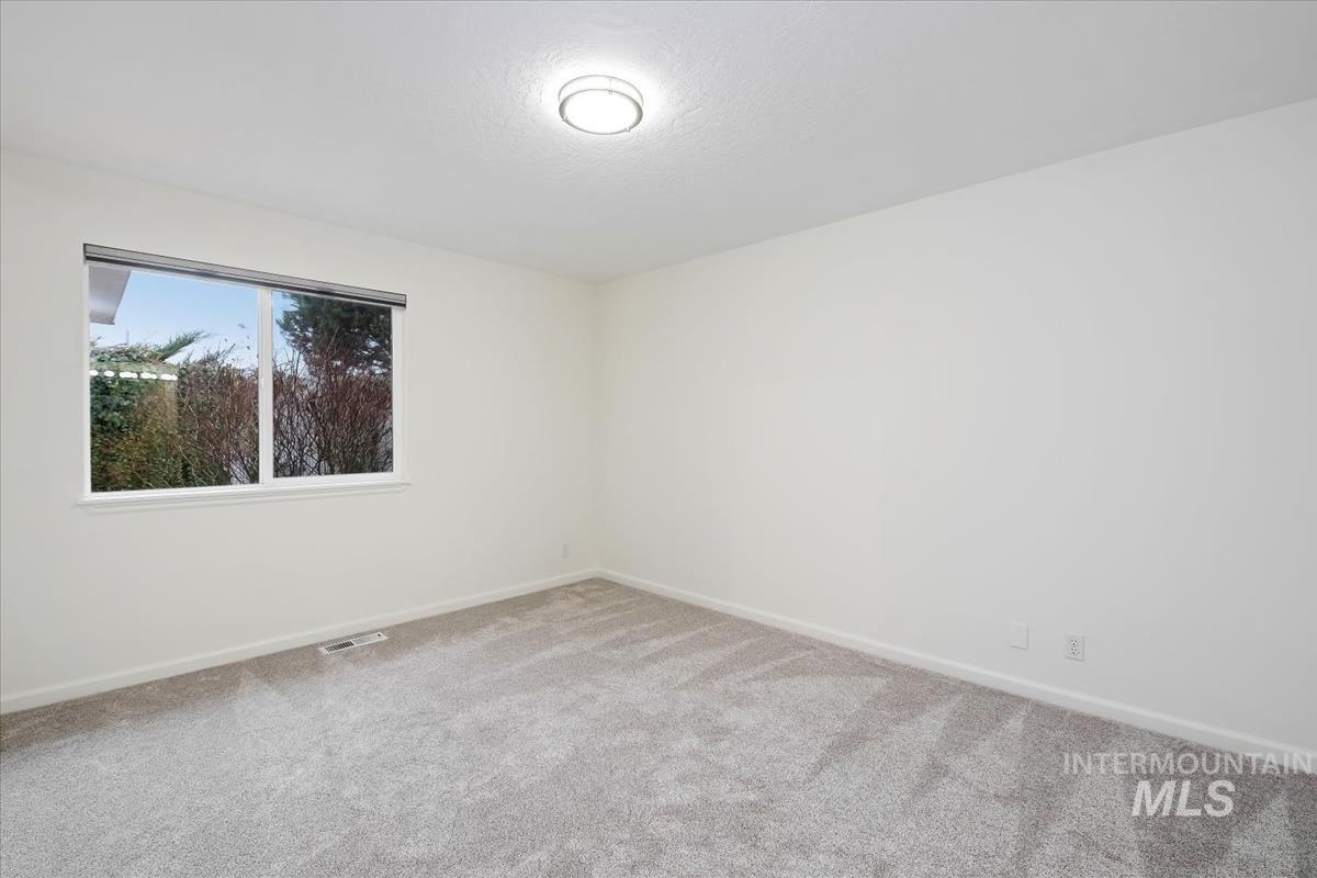 Carpeted empty room with baseboards