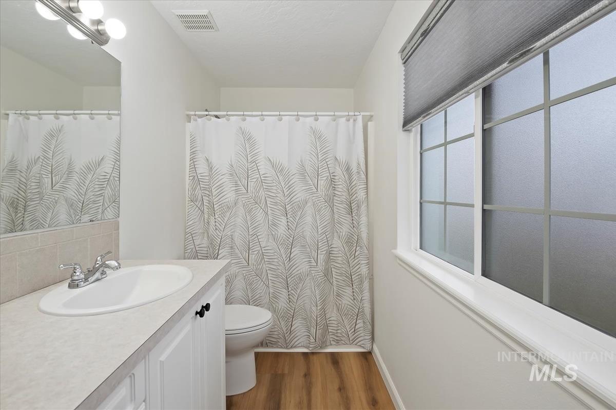 Full bathroom with vanity, LVP flooring, and curtained shower