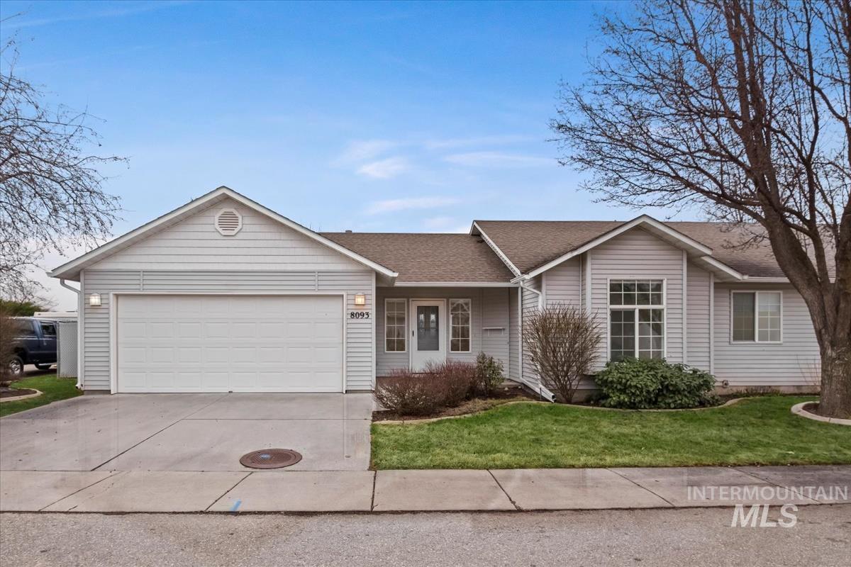 Home featuring a front yard, covered porch, concrete driveway, and a two-car garage