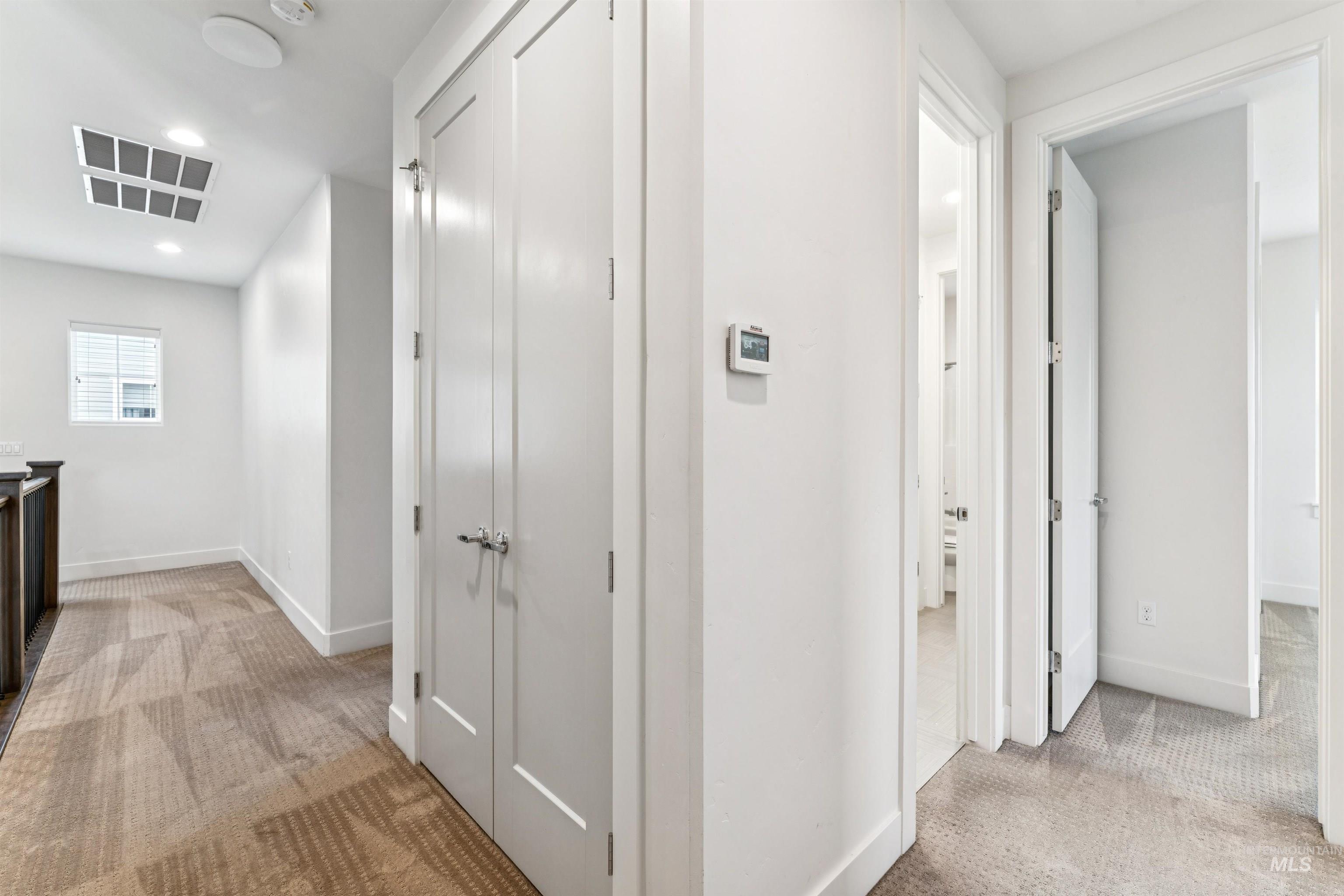 Hallway featuring light carpet and recessed lighting