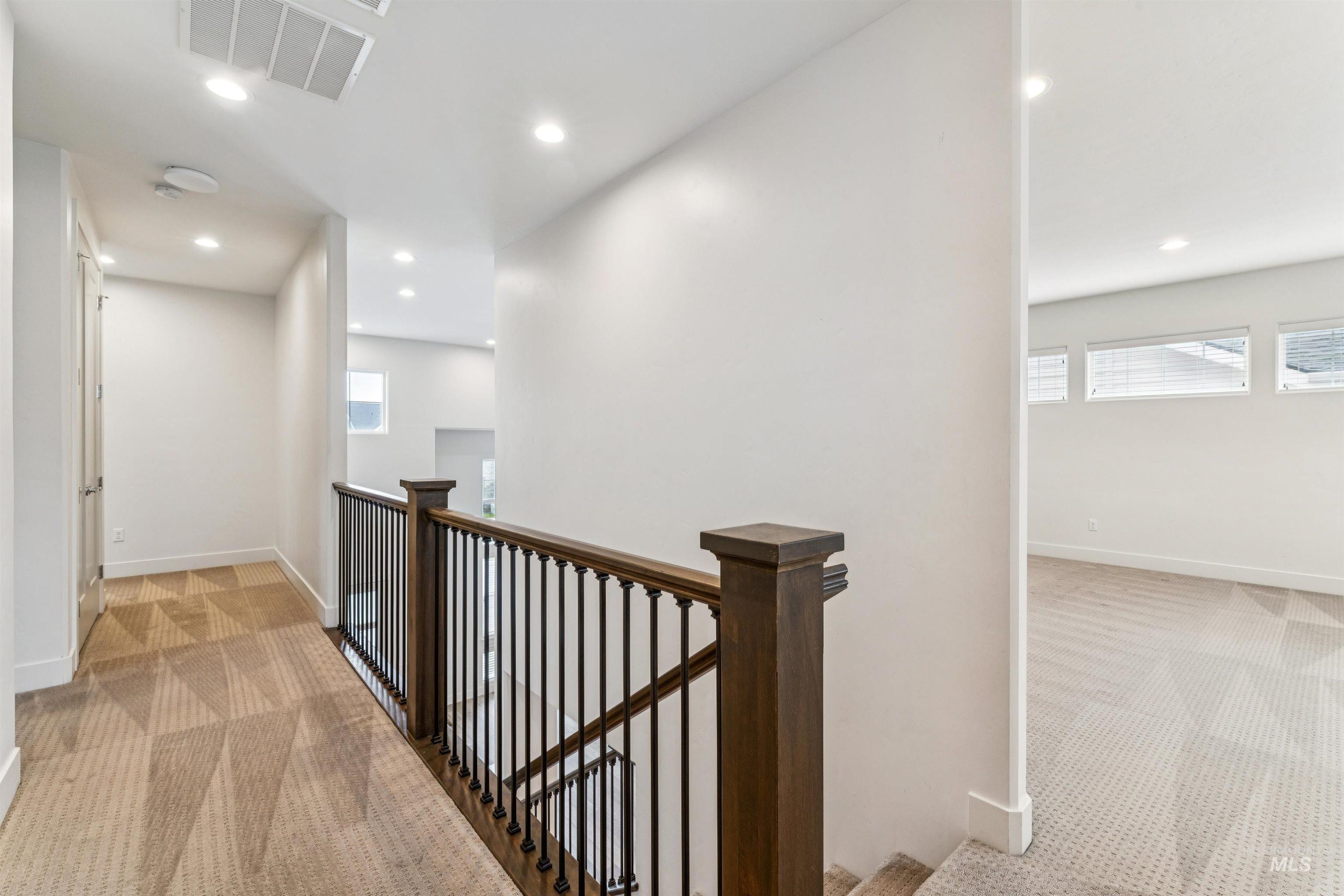 Hall featuring light colored carpet, an upstairs landing, and recessed lighting