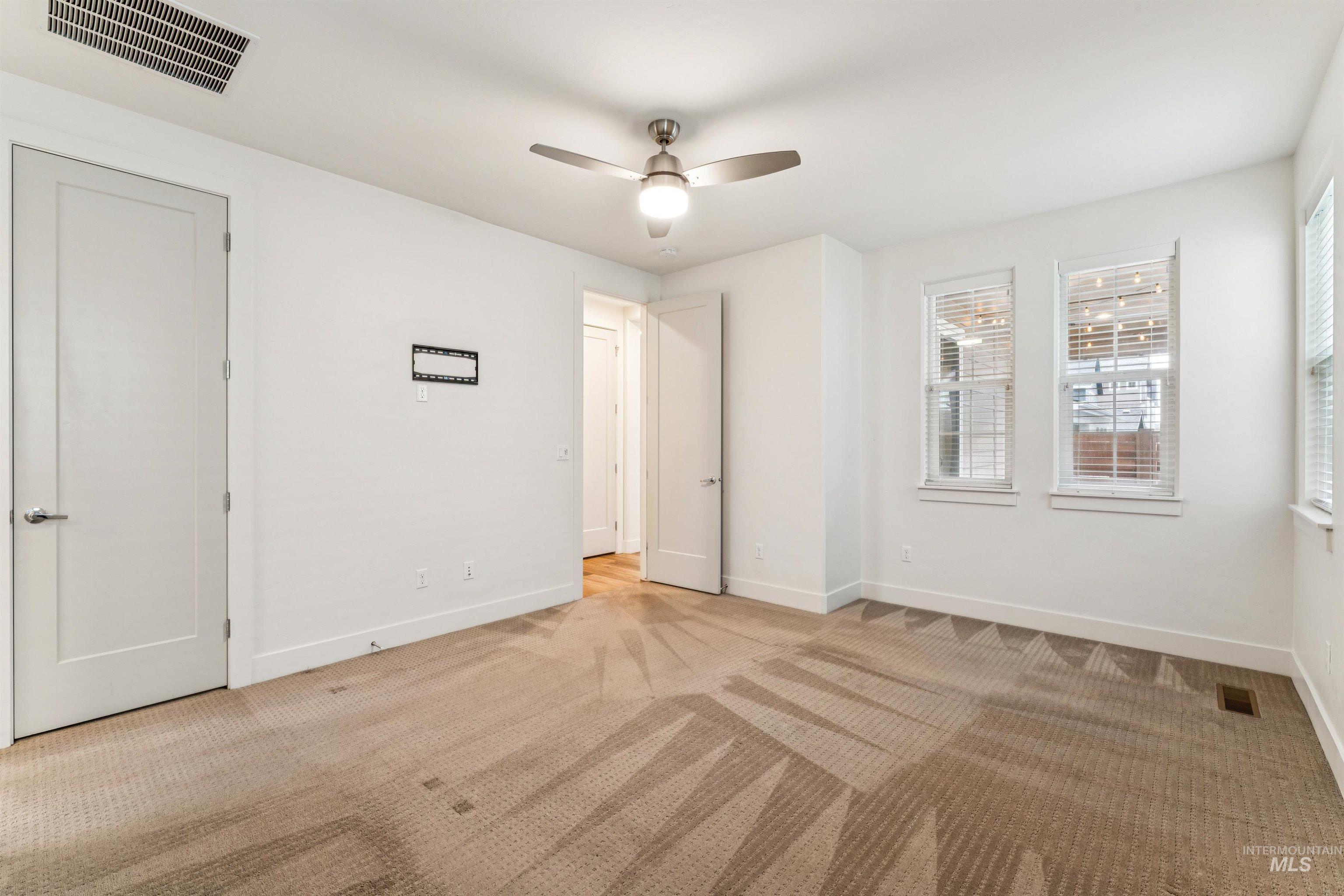 Primary bedroom with additional closet and a ceiling fan