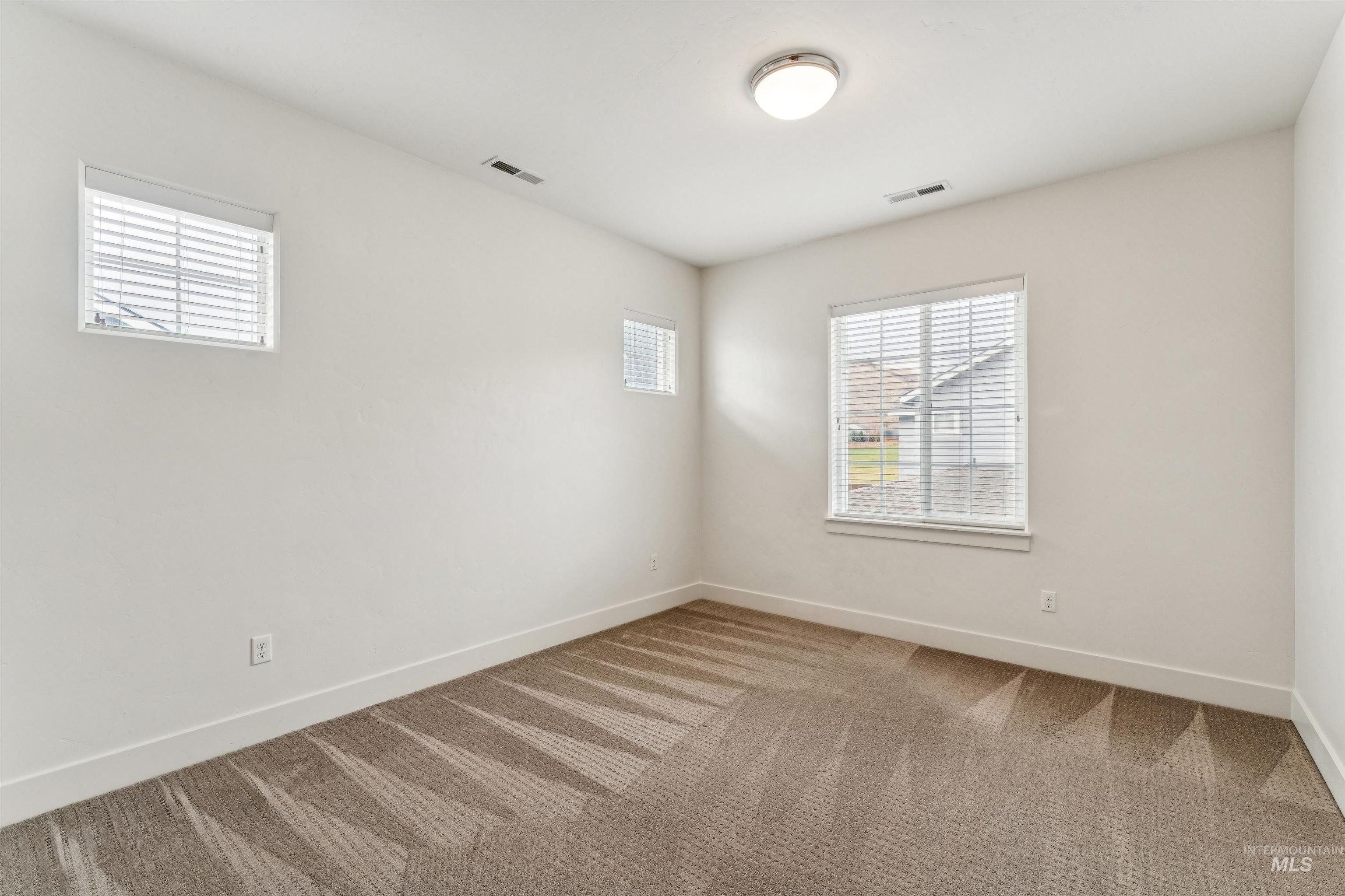 Bedroom with healthy amount of natural light and light colored carpet