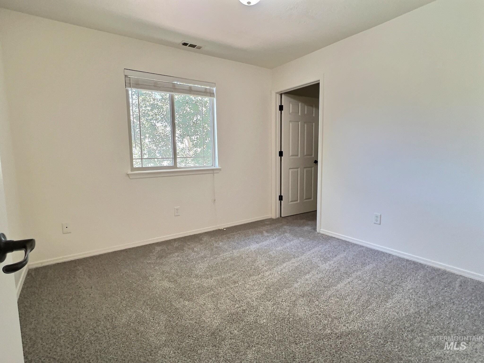 Carpeted empty room with baseboards