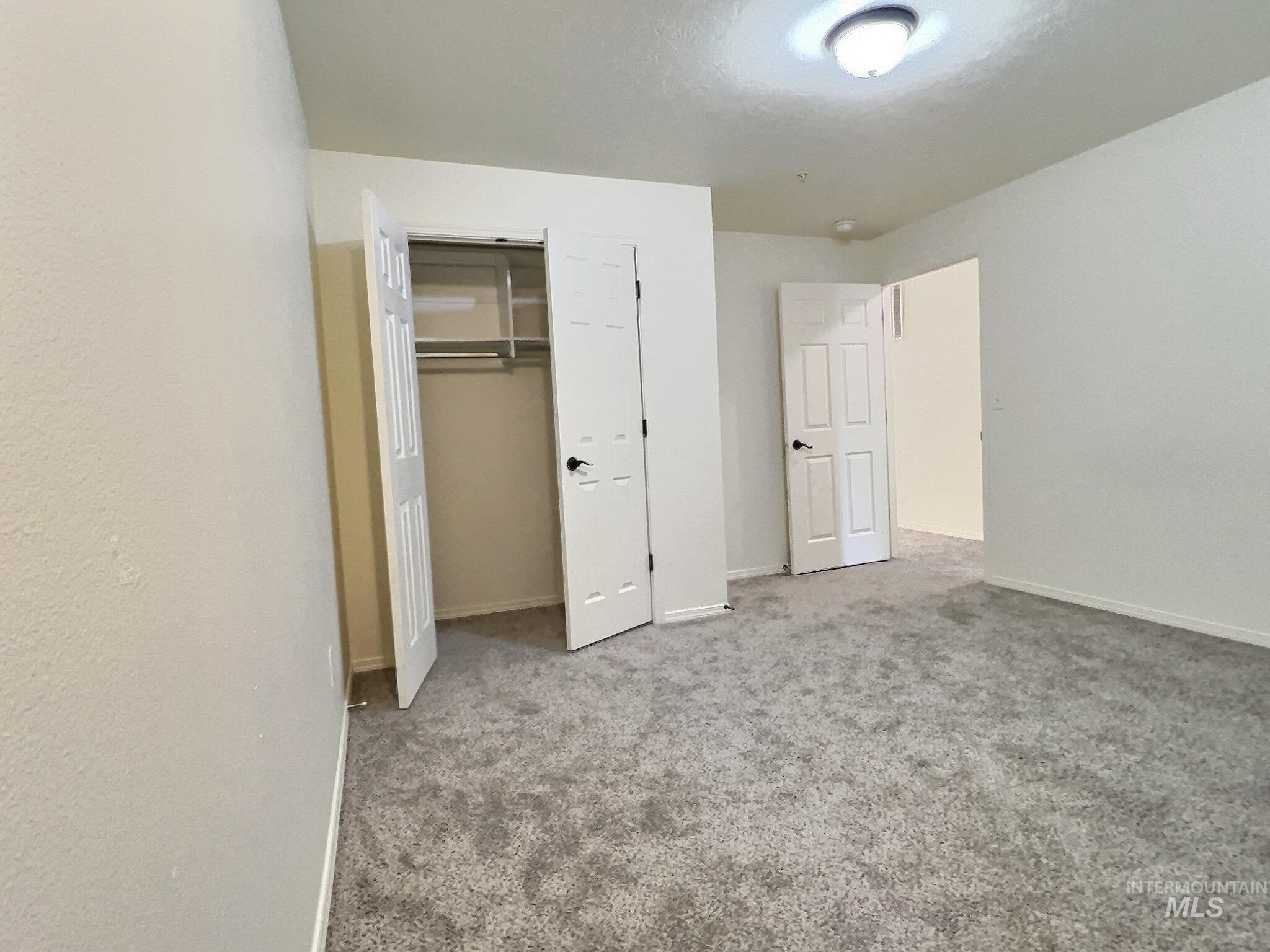 Unfurnished bedroom featuring carpet flooring and a closet