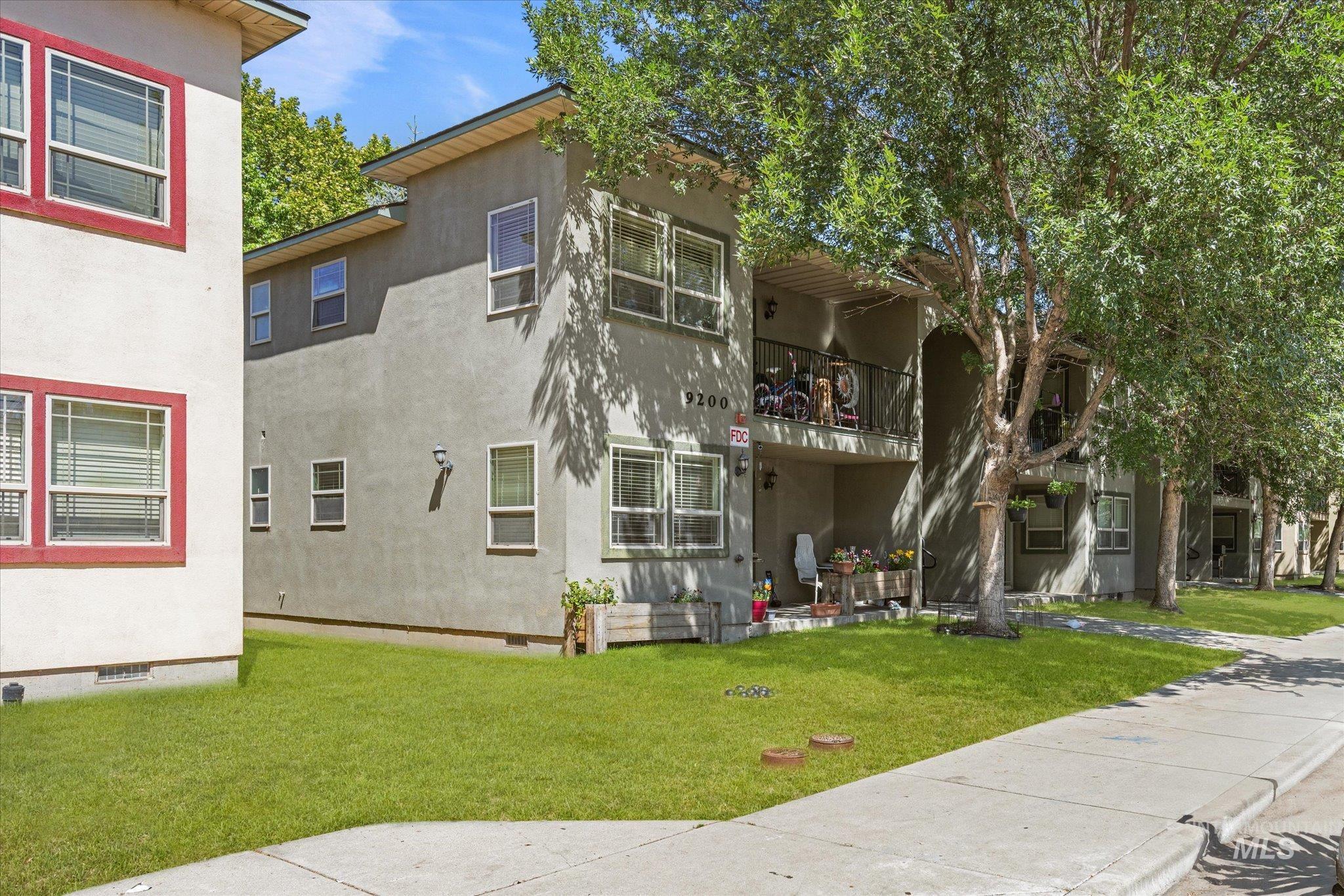 Back of property with crawl space, a lawn, a balcony, and stucco siding