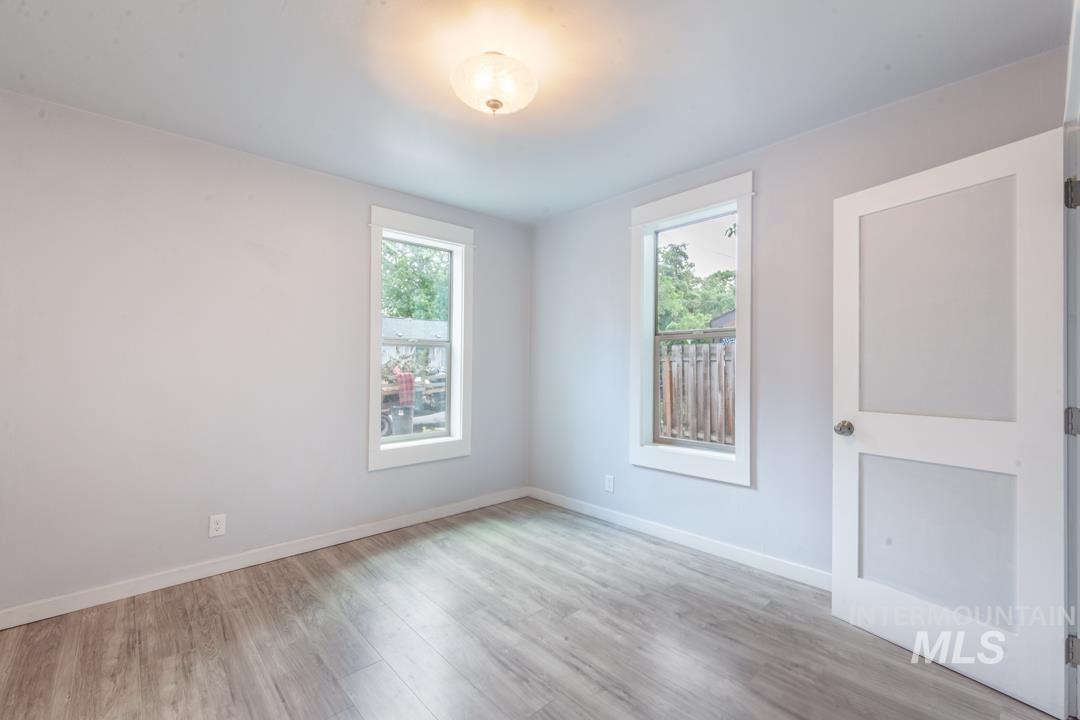 Unfurnished room with wood finished floors and plenty of natural light