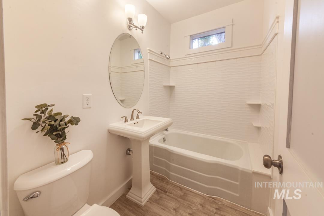 Bathroom with shower / bath combination and wood finished floors