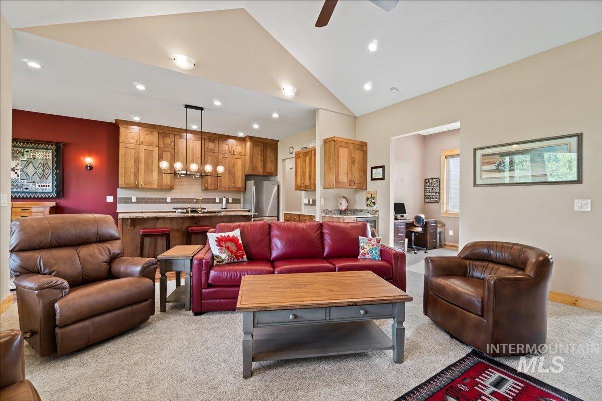 Living room featuring recessed lighting, light carpet, lofted ceiling, and a ceiling fan