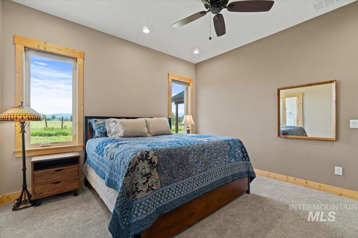 Carpeted bedroom featuring multiple windows, recessed lighting, and a ceiling fan
