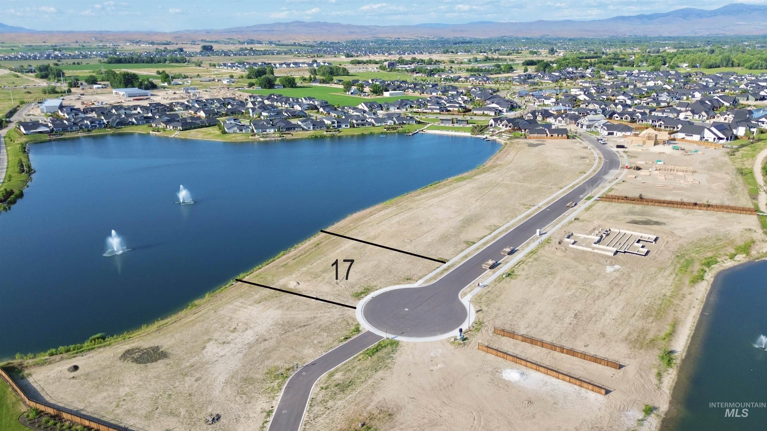 Aerial view of property's location featuring a water and mountain view and nearby suburban area