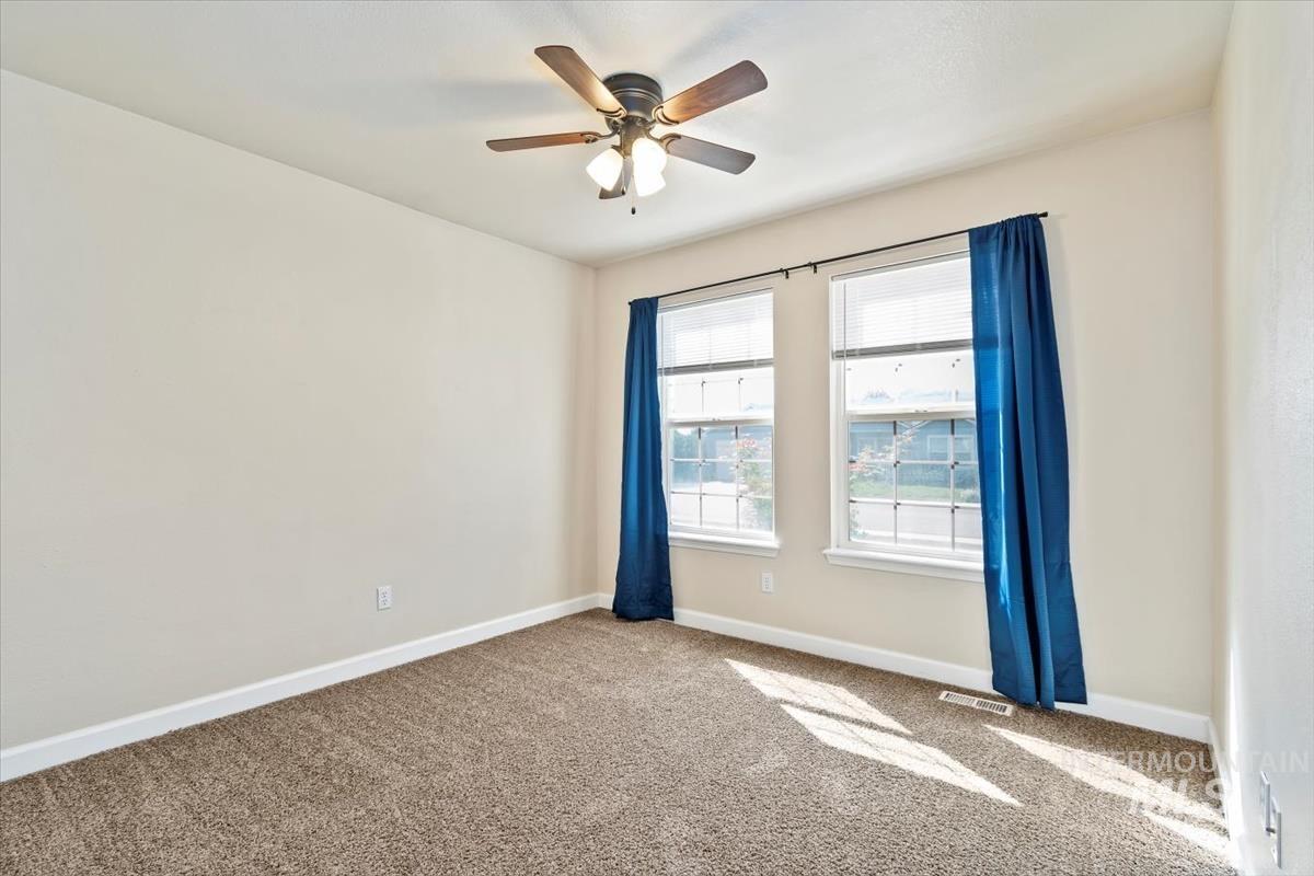 Spare room featuring carpet flooring and a ceiling fan