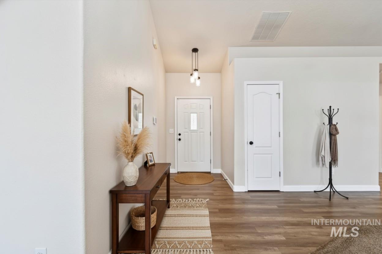 Foyer featuring dark wood-type flooring and baseboards