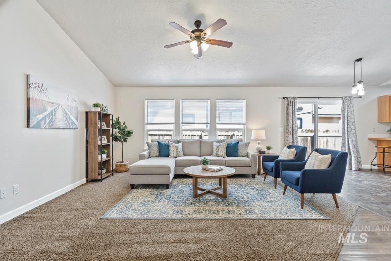 Living room with ceiling fan and a textured ceiling