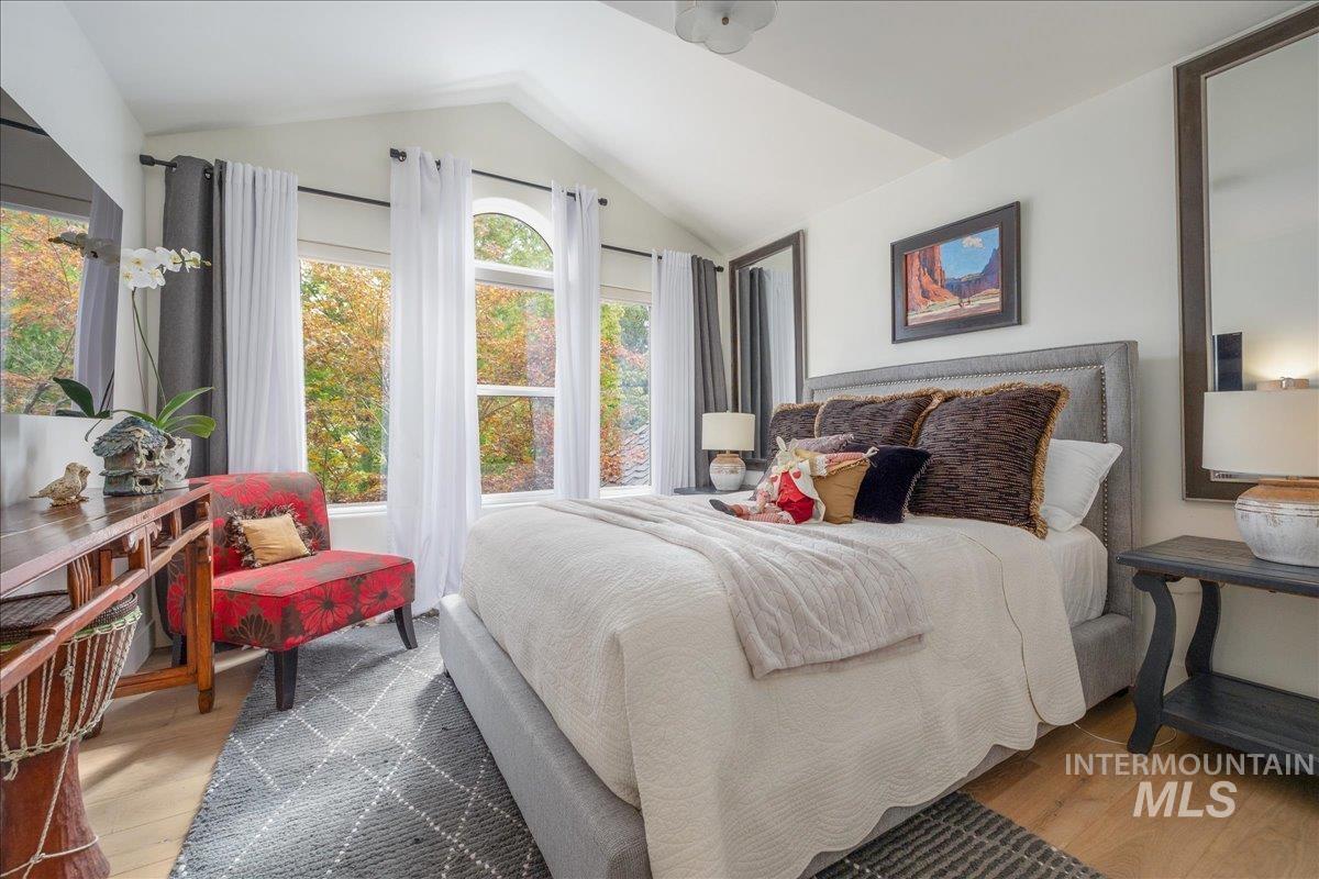 Bedroom featuring wood finished floors and lofted ceiling
