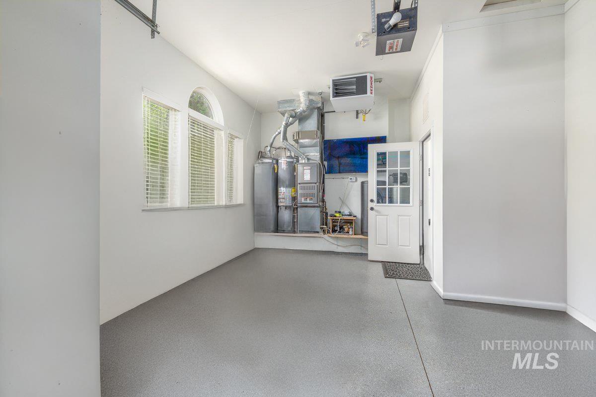 Garage featuring a heating unit and gas water heater