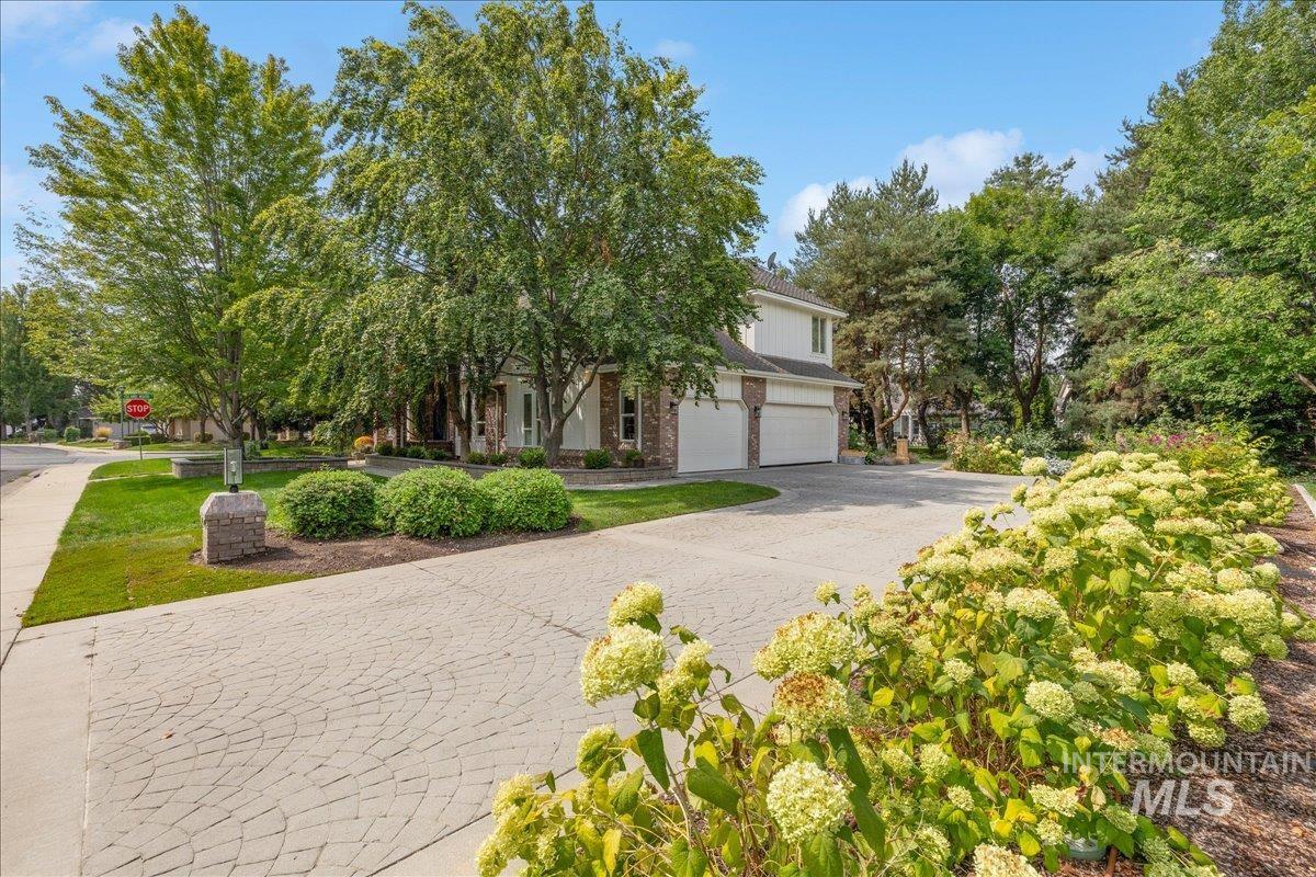 Obstructed view of property with decorative driveway